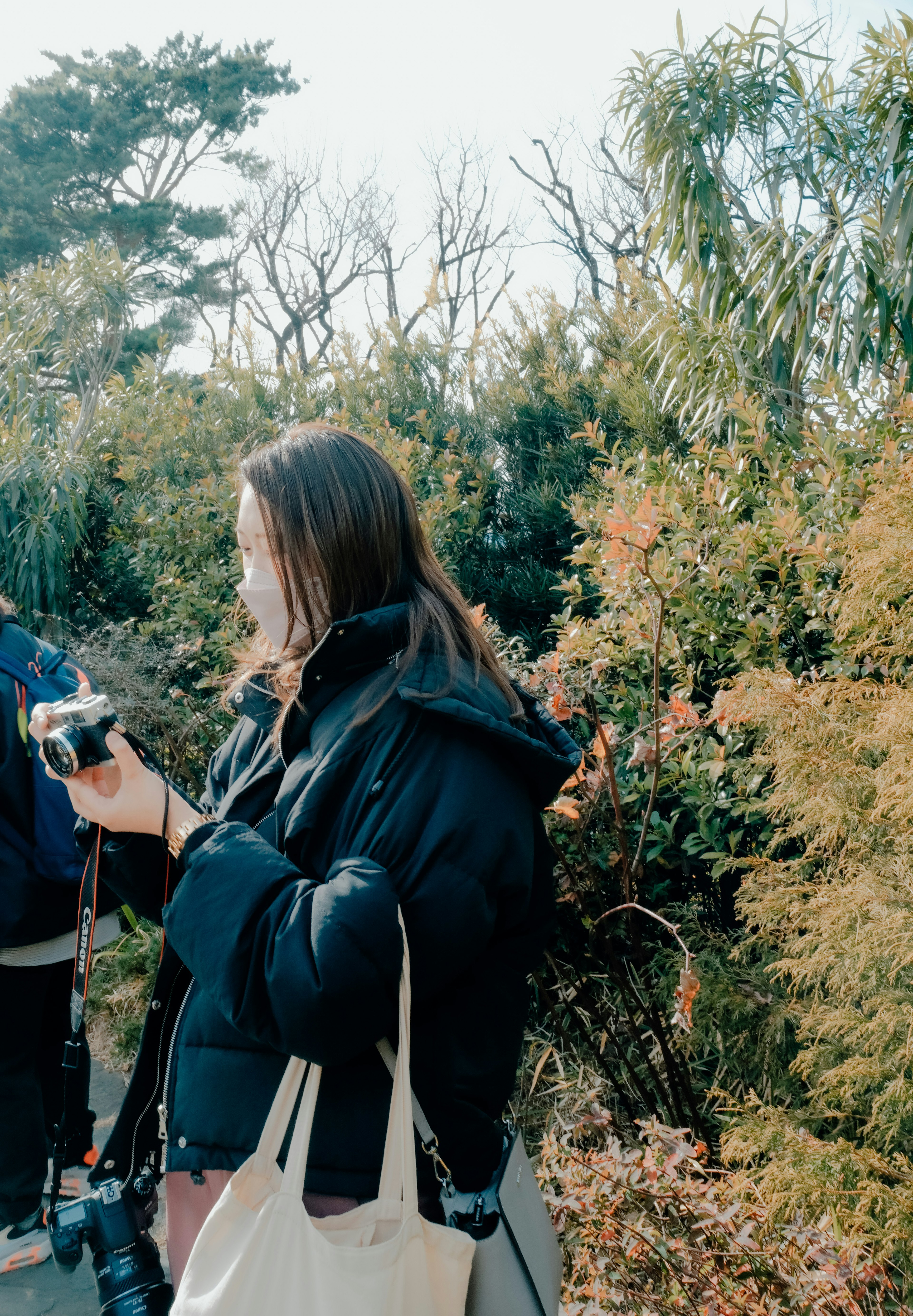 A woman holding a camera in a natural setting