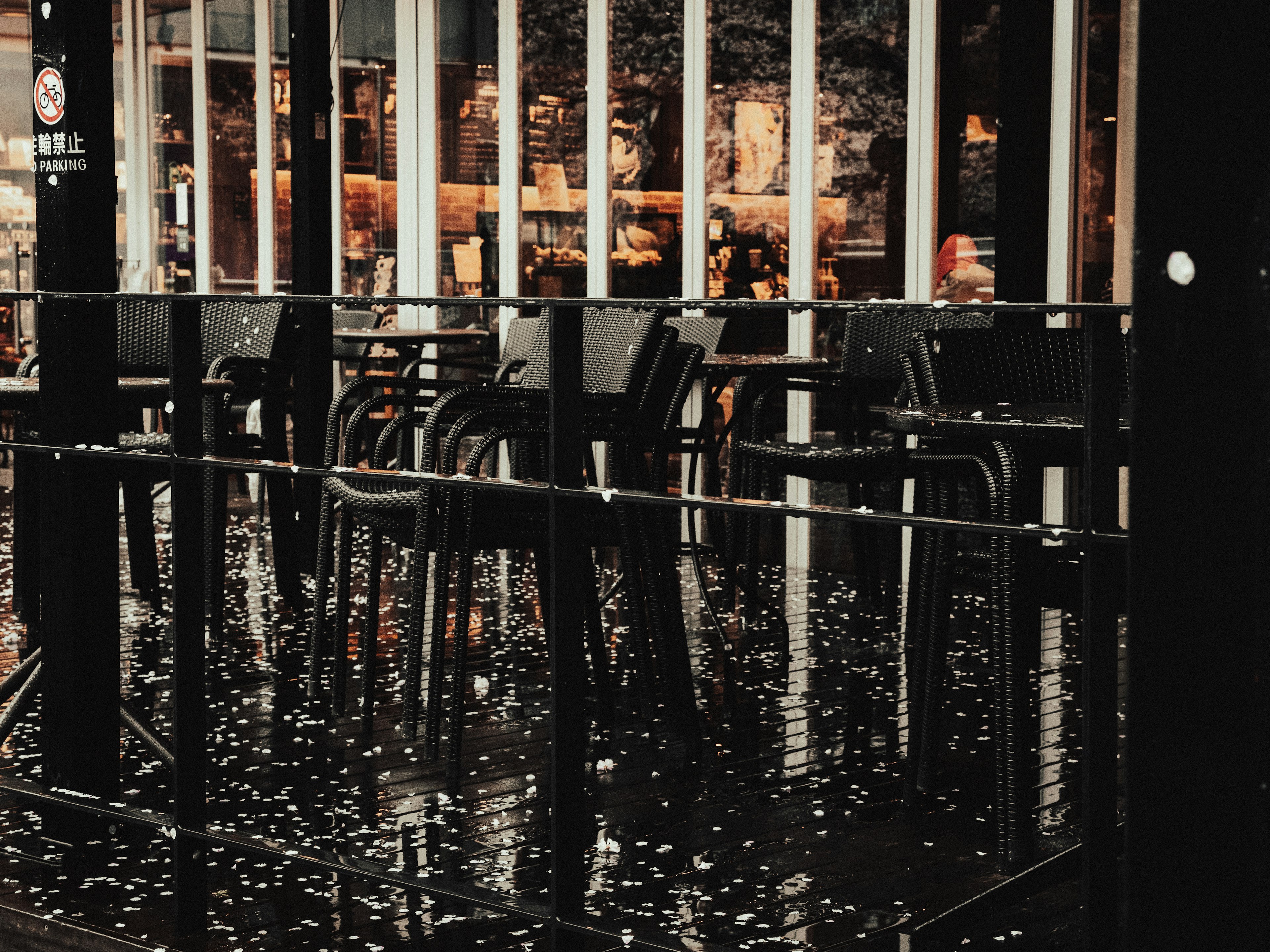 Terrasse de café extérieure avec des chaises et des tables mouillées après la pluie