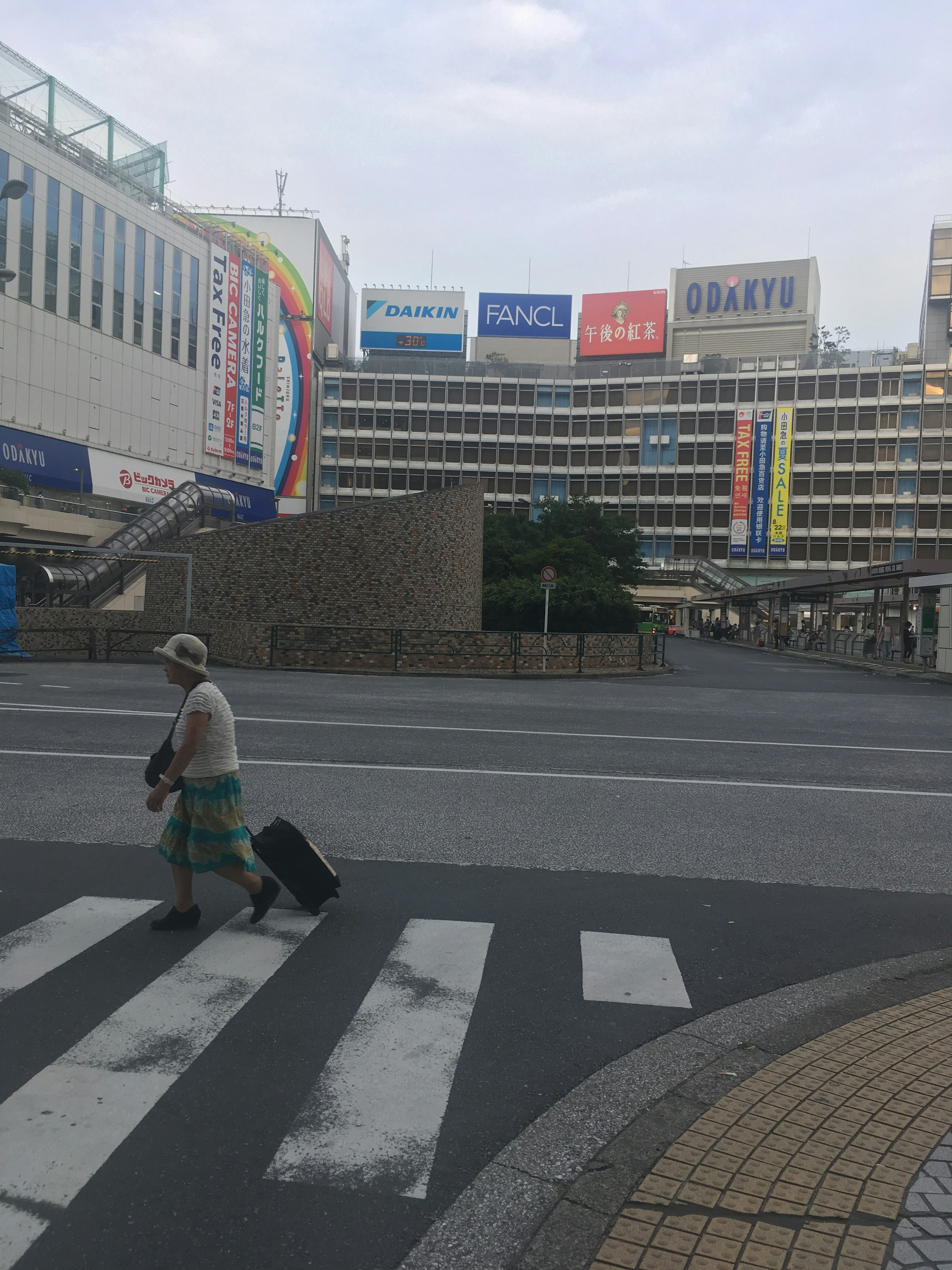 Eine Person, die die Straße mit einem Koffer überquert