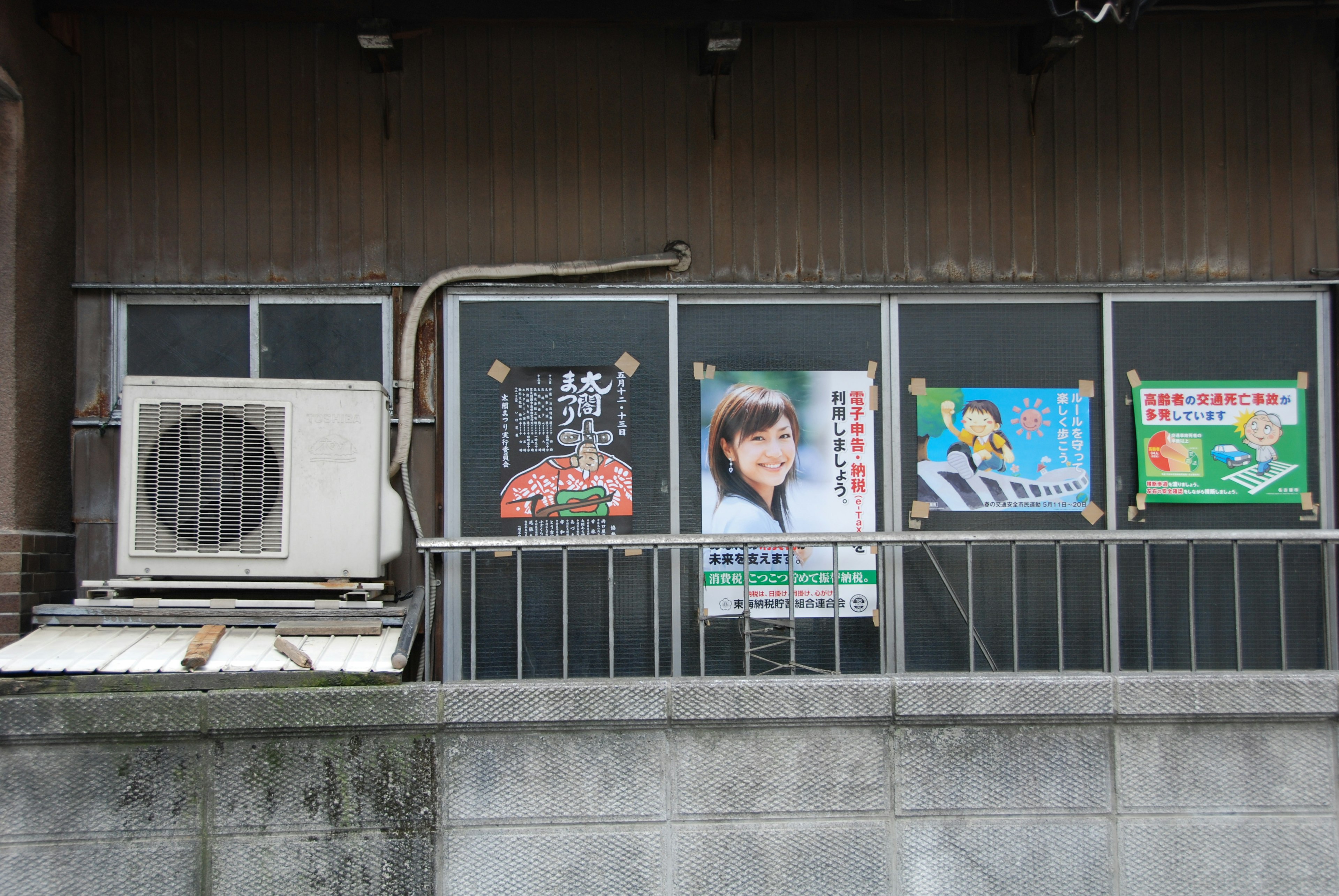 Exterior view of a window with advertisements and an air conditioning unit