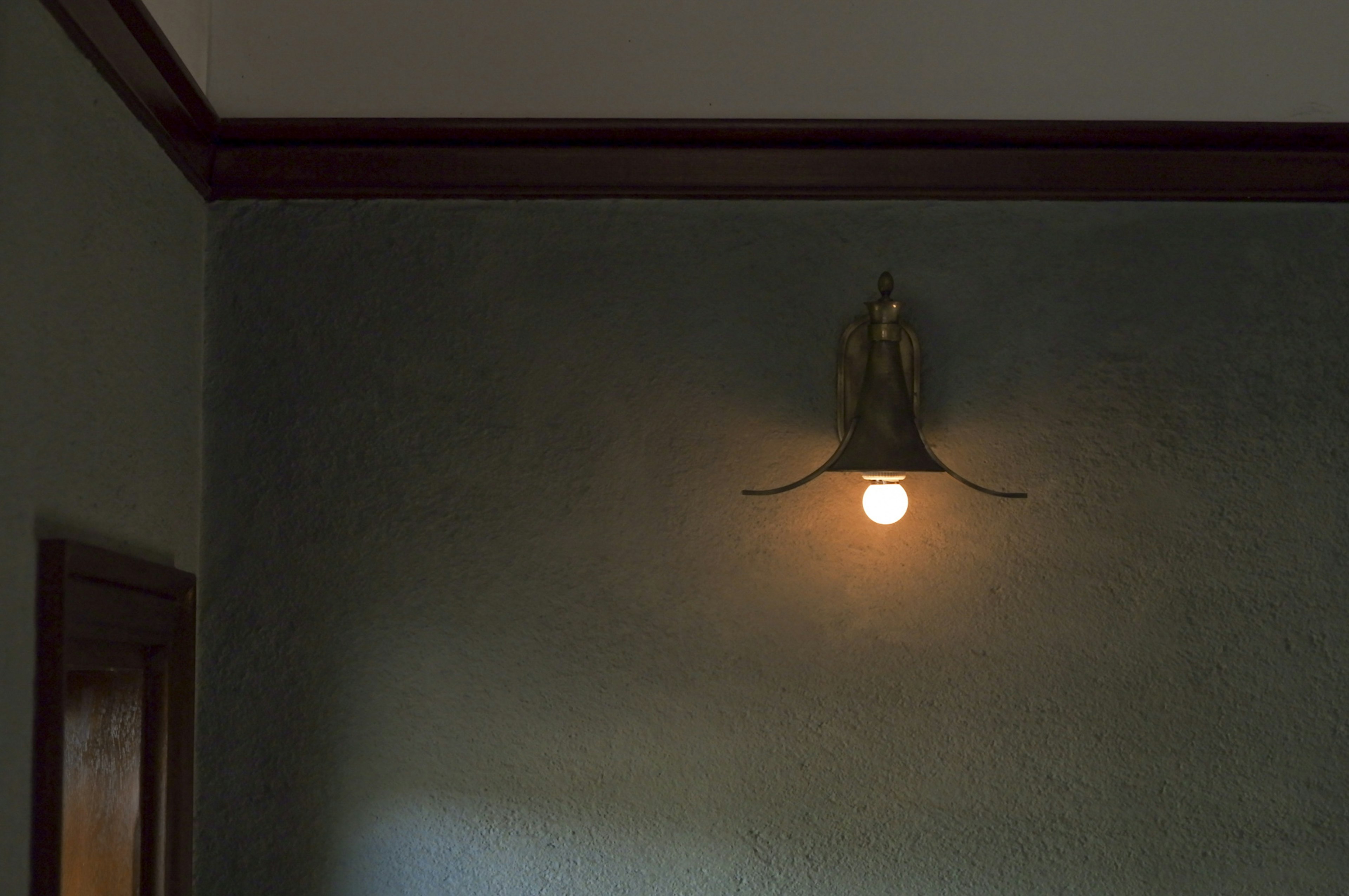 Antique style wall lamp illuminated on a green wall