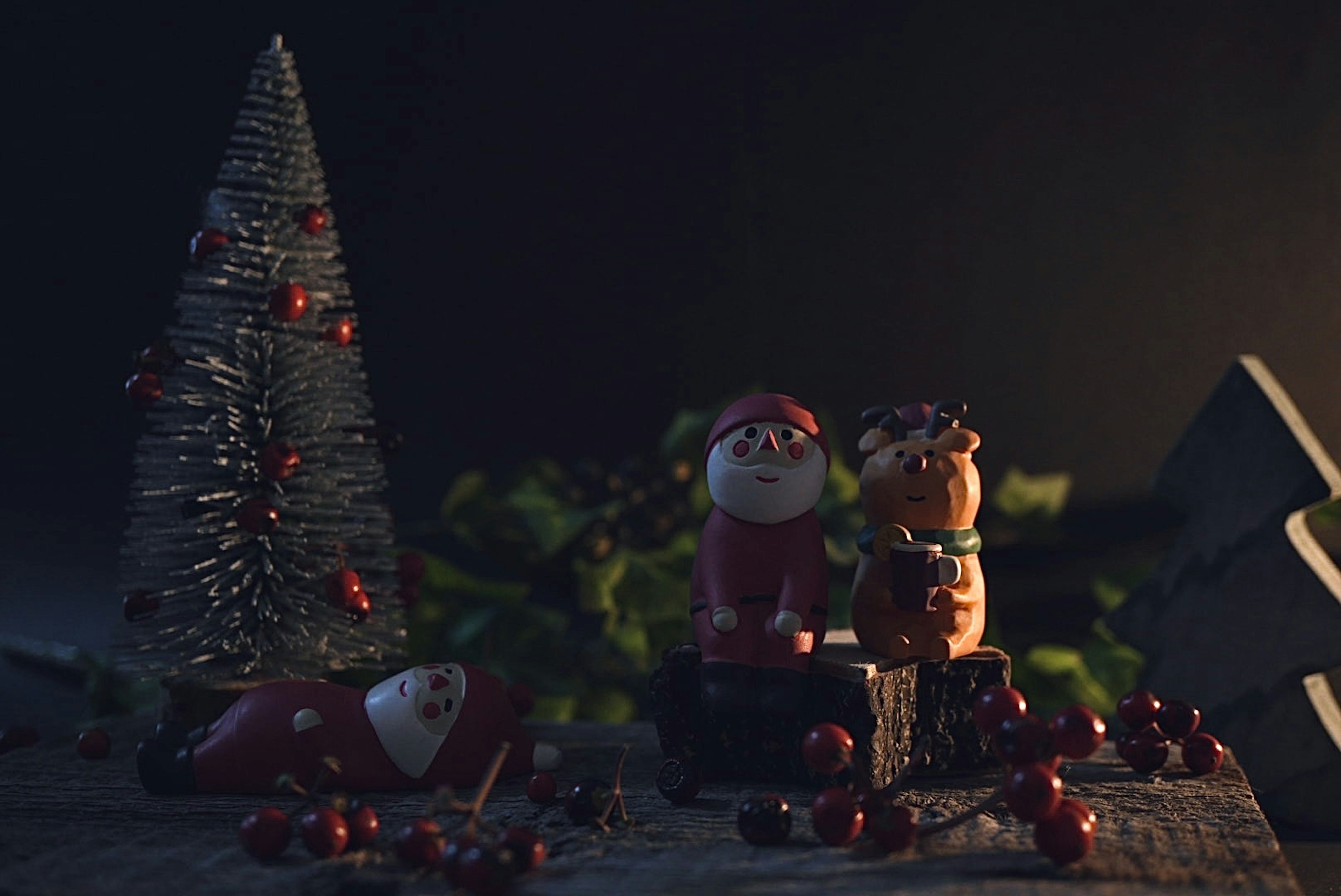 Escena cálida con decoraciones navideñas figuras de Santa Claus y perro mini árbol y adornos de bayas rojas