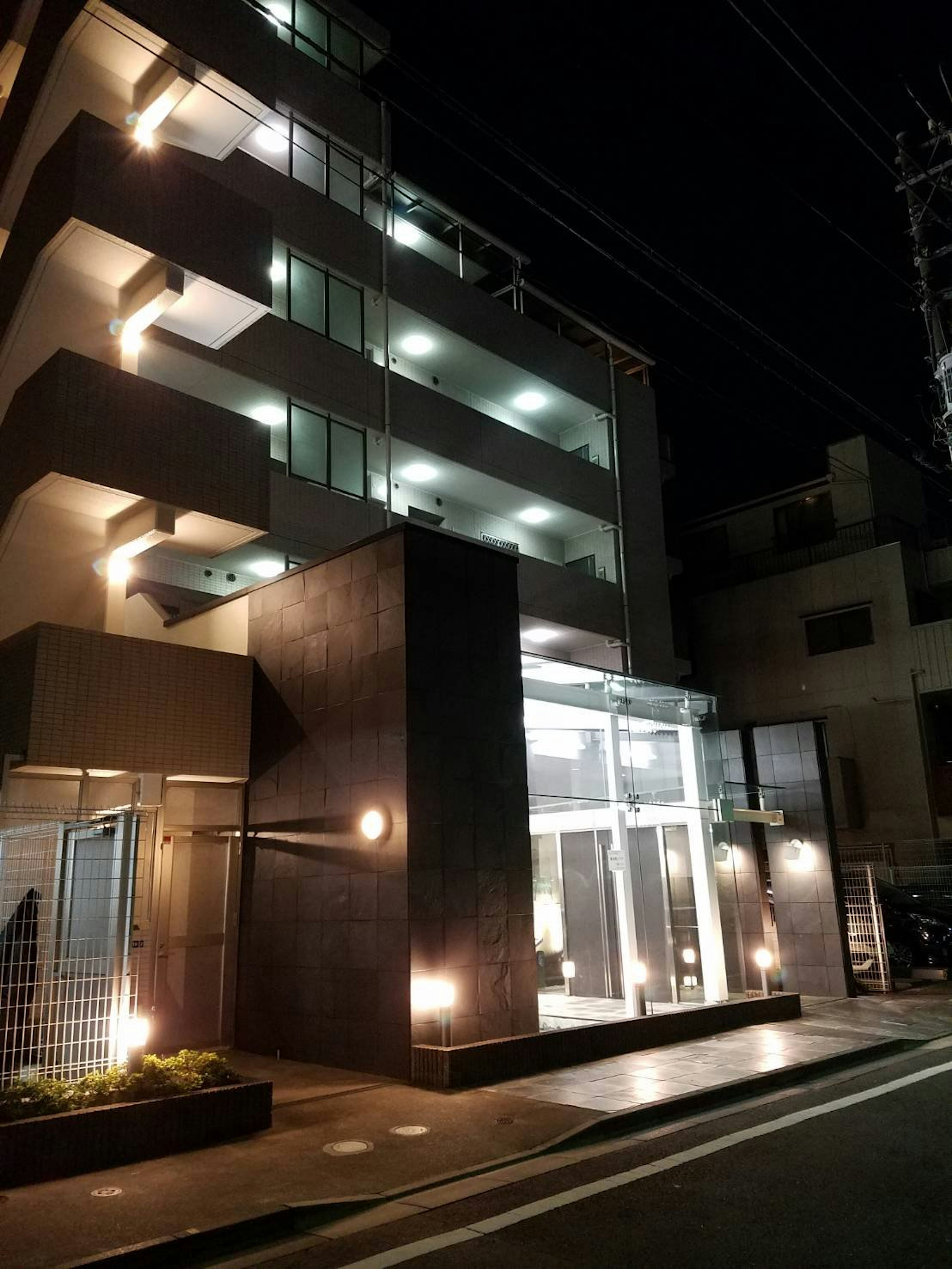 Exterior de un edificio moderno de apartamentos en un entorno urbano nocturno