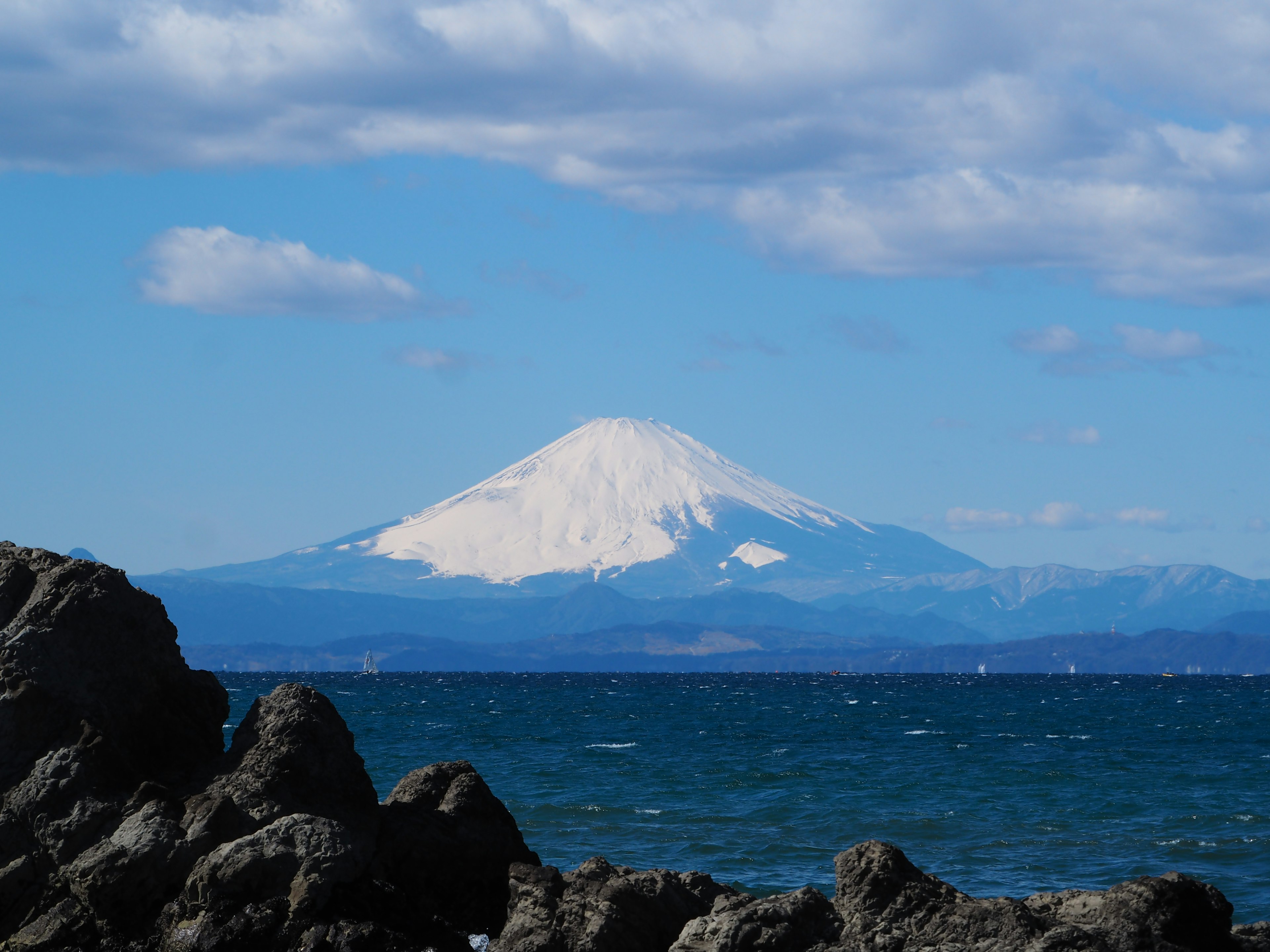 Vista panoramica di una montagna innevata con un oceano blu