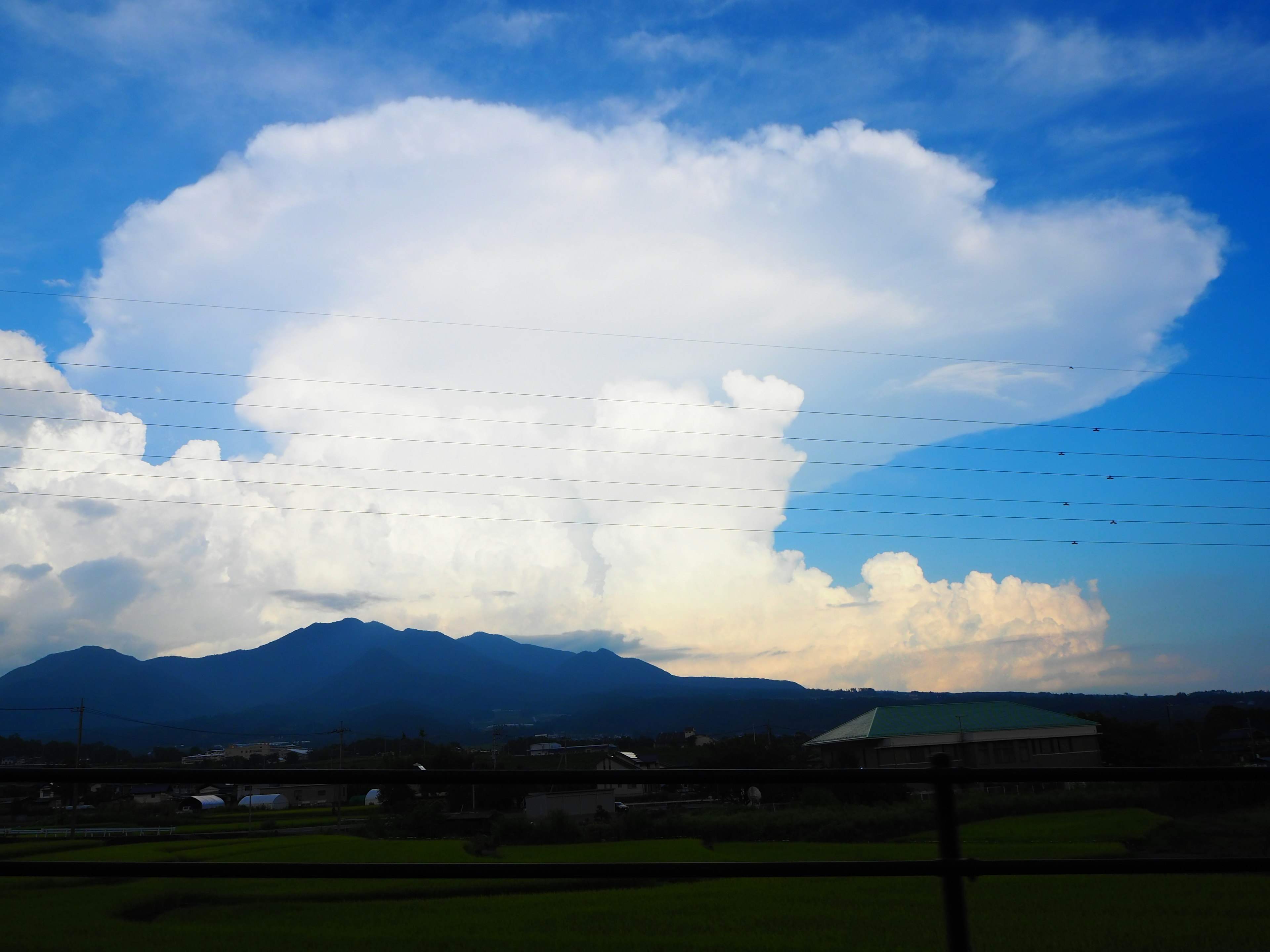 Grands nuages blancs dans un ciel bleu avec des montagnes en arrière-plan