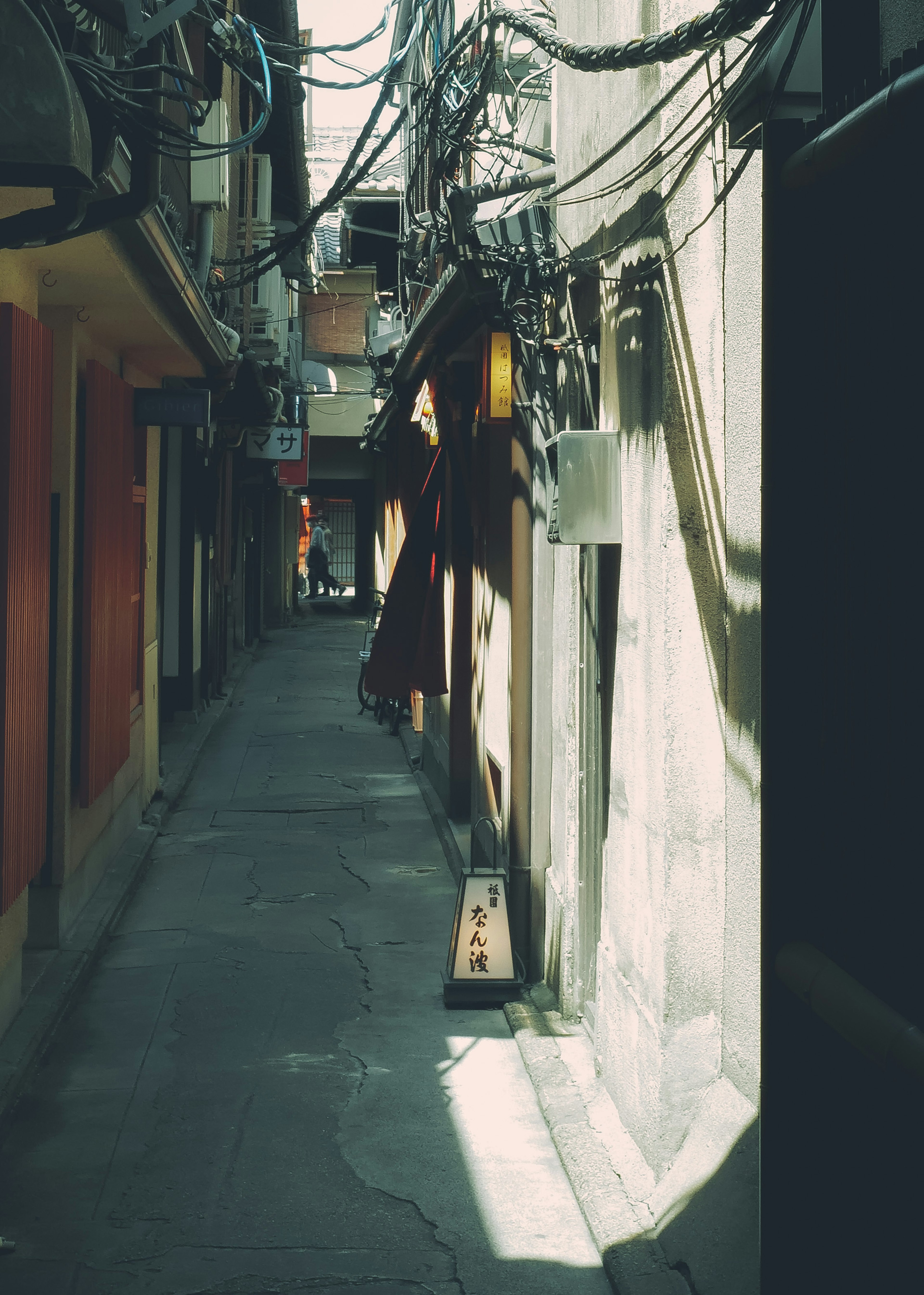 Narrow alleyway with walls and overhead wires