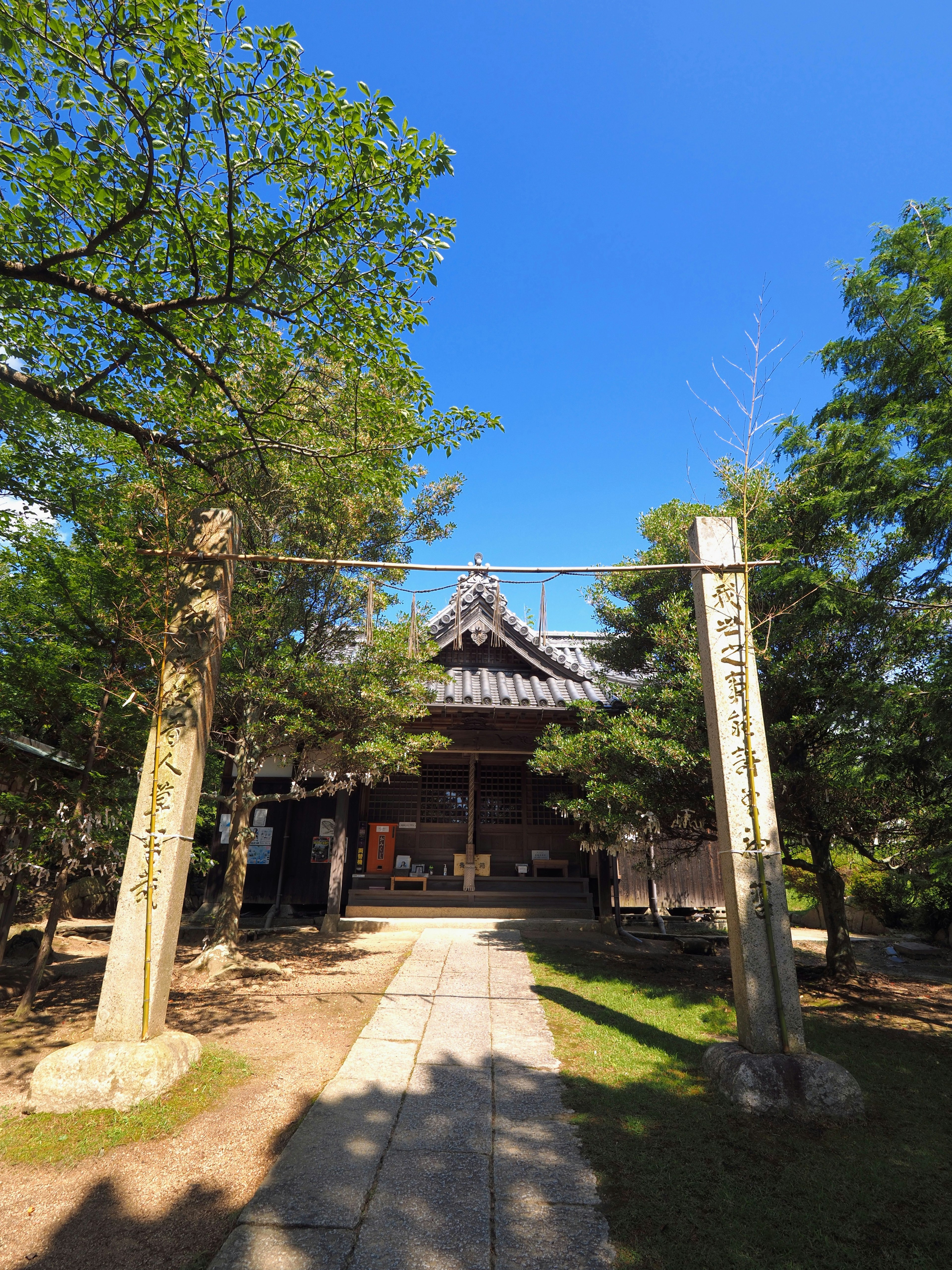 Une entrée de temple traditionnel entourée d'arbres sous un ciel bleu