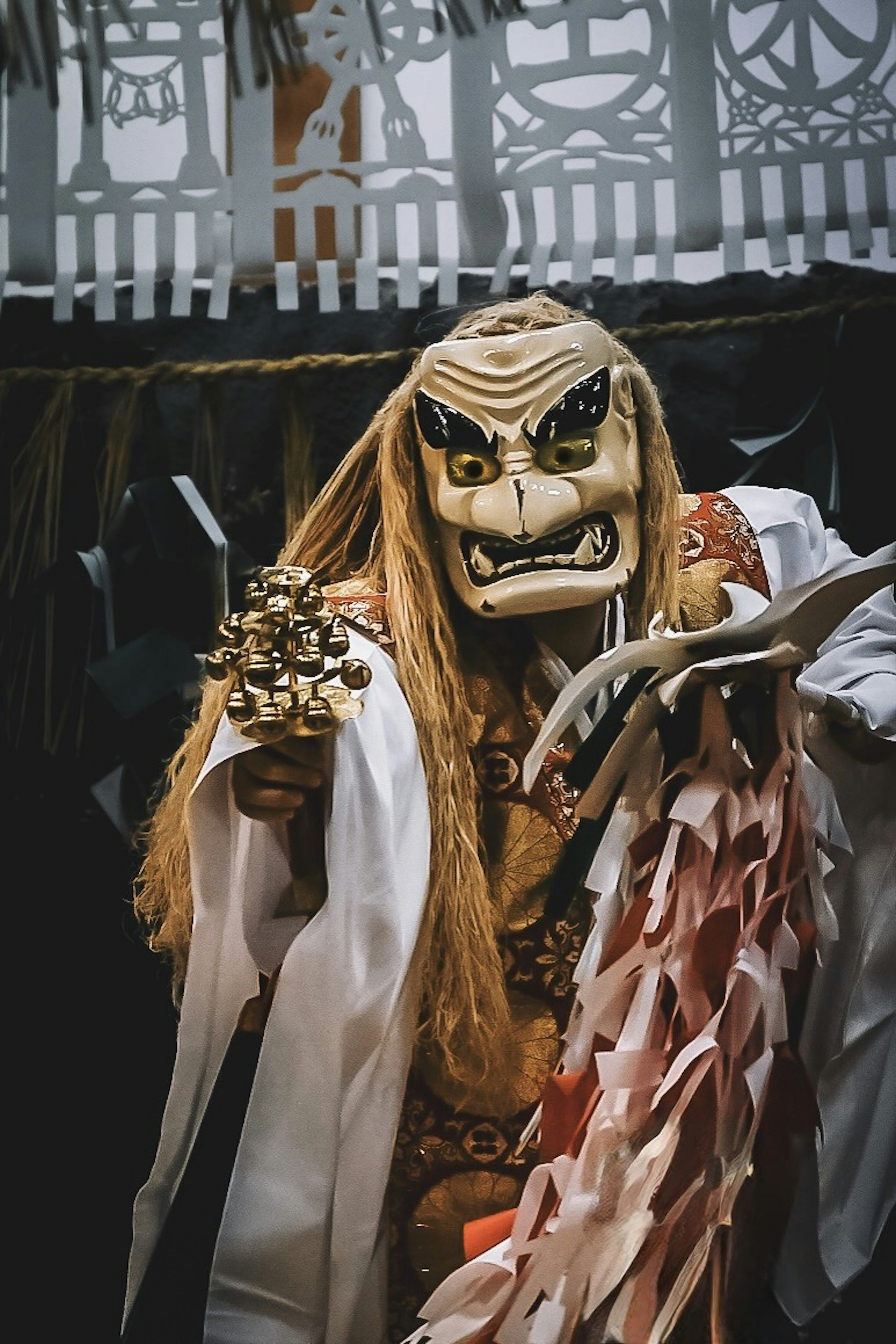 A character in a traditional mask striking a mystical pose