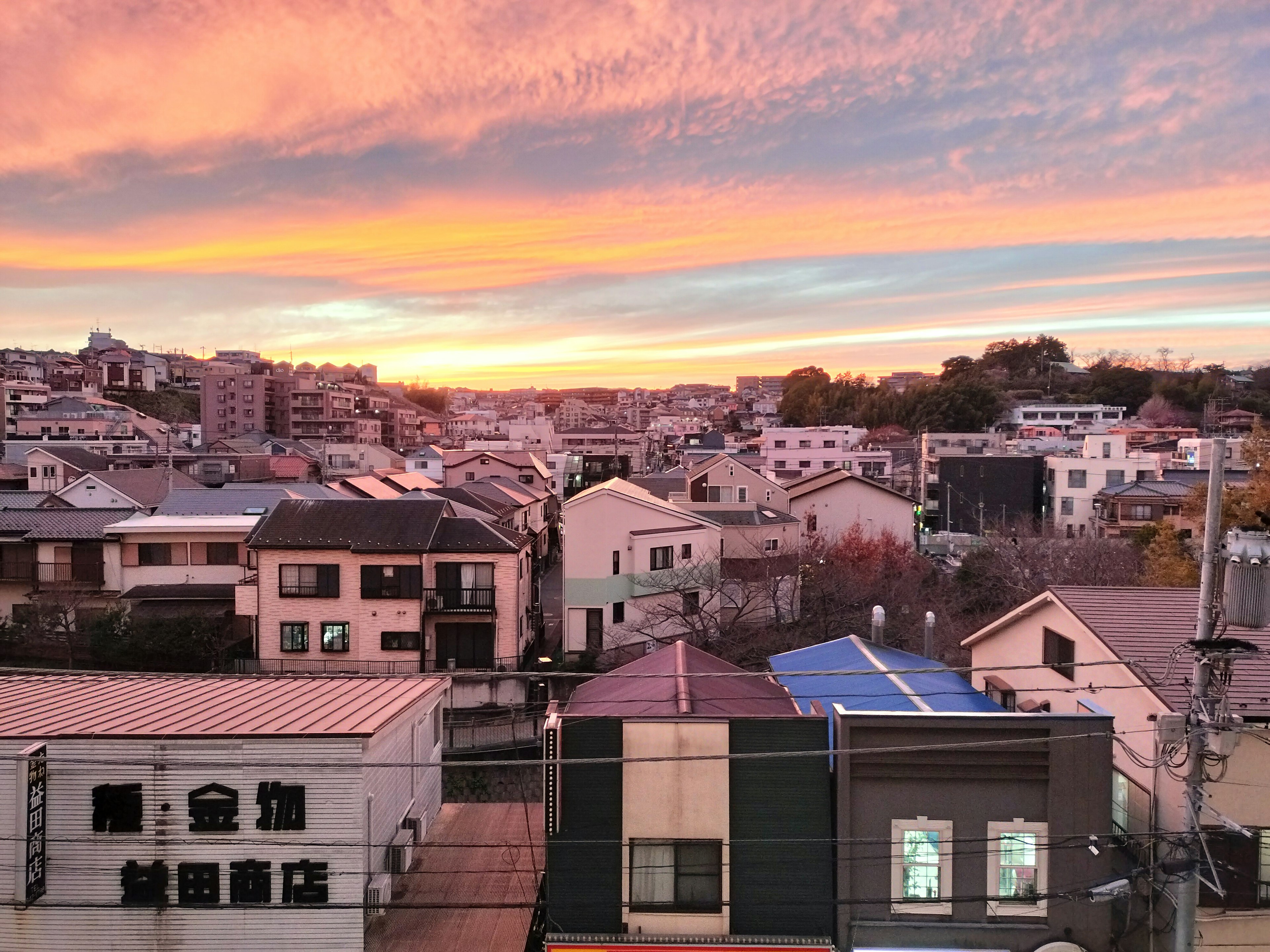 Panorama urbano al tramonto con cielo colorato e case