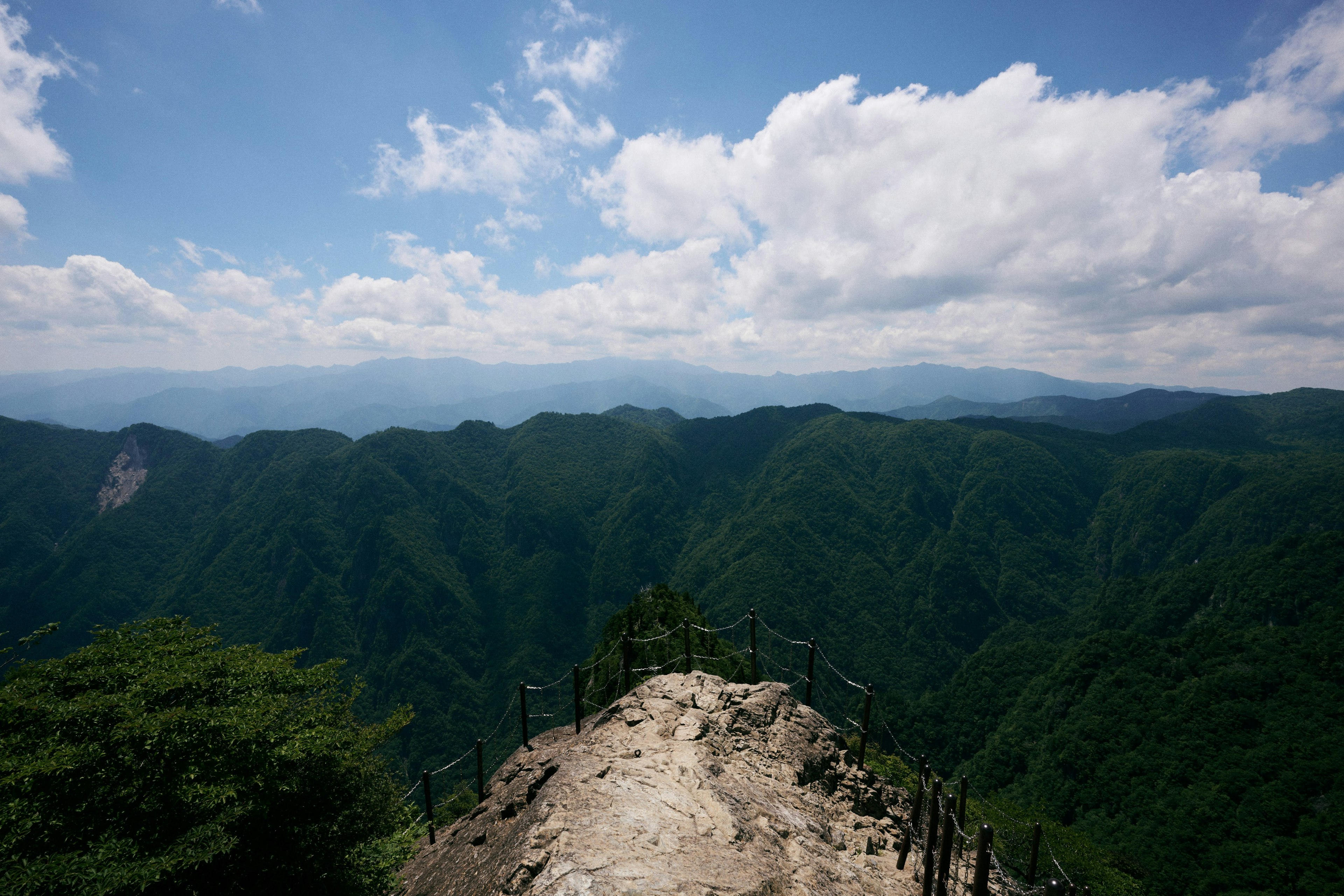 緑豊かな山々と青い空が広がる風景の頂上からの眺め