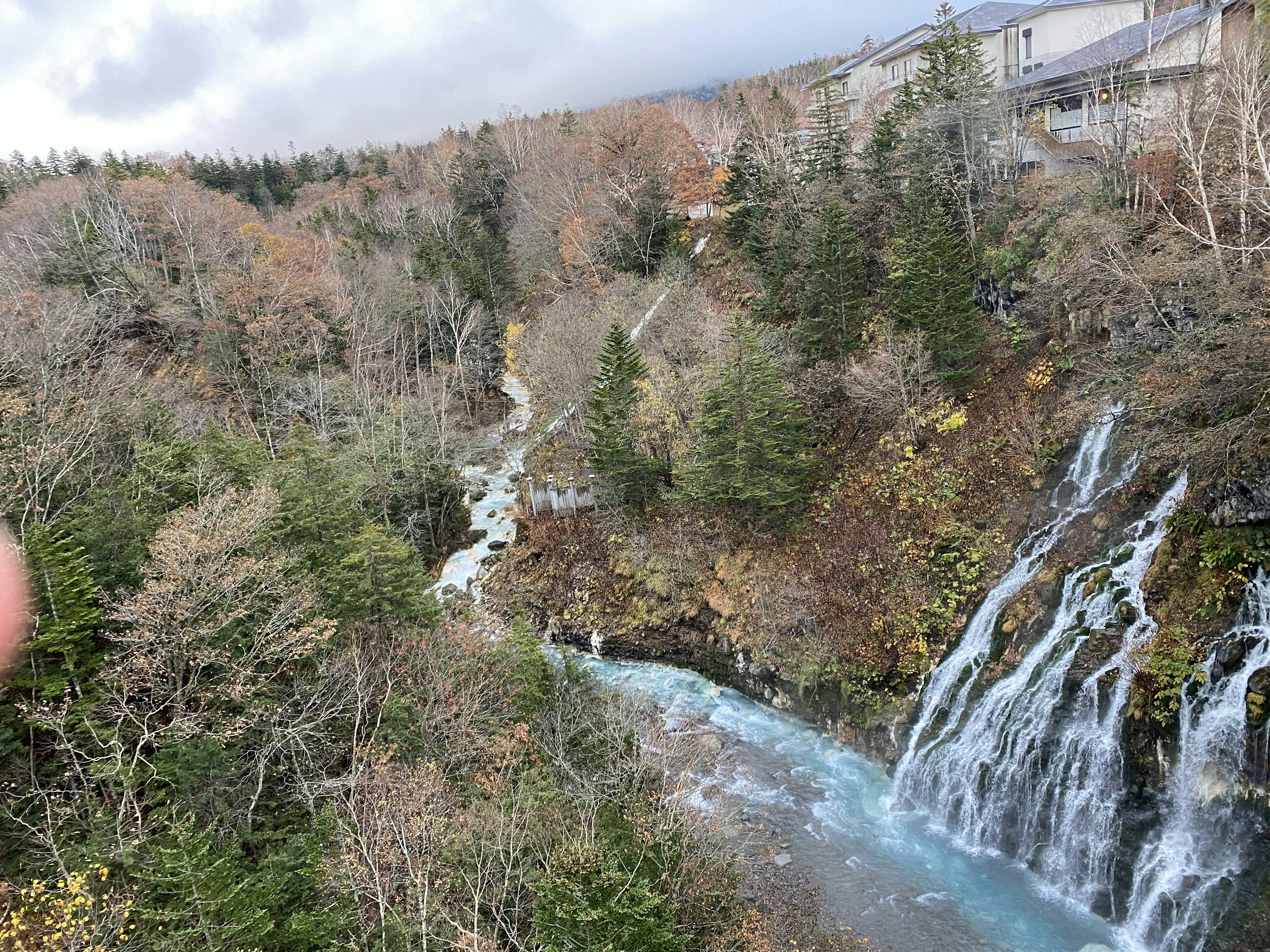 Vue pittoresque d'une cascade et d'une rivière bleue avec un feuillage d'automne et des arbres environnants