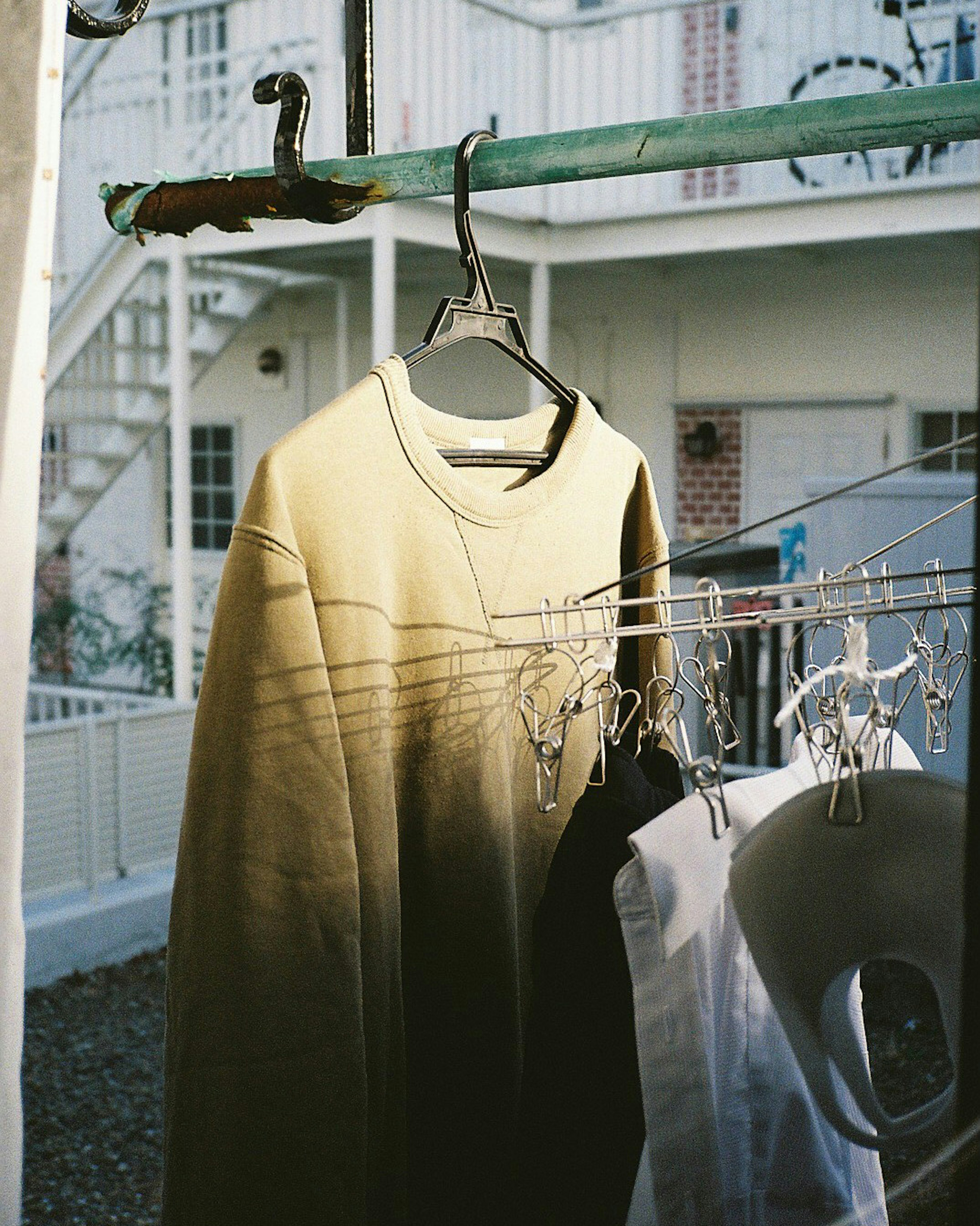 Una escena de ropa tendida con una sudadera verde oliva colgada en una percha