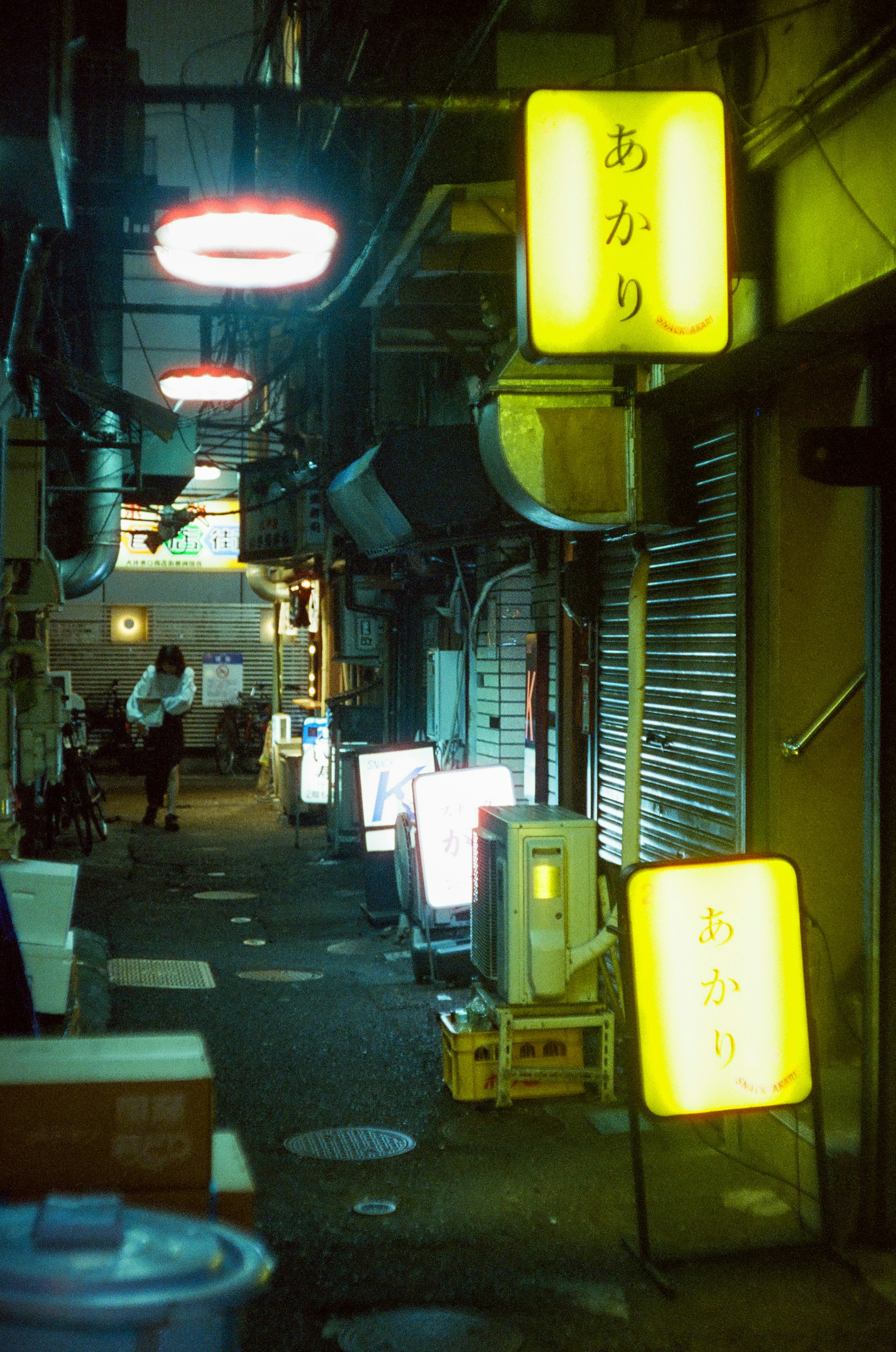 夜の路地にある明るい看板と人影