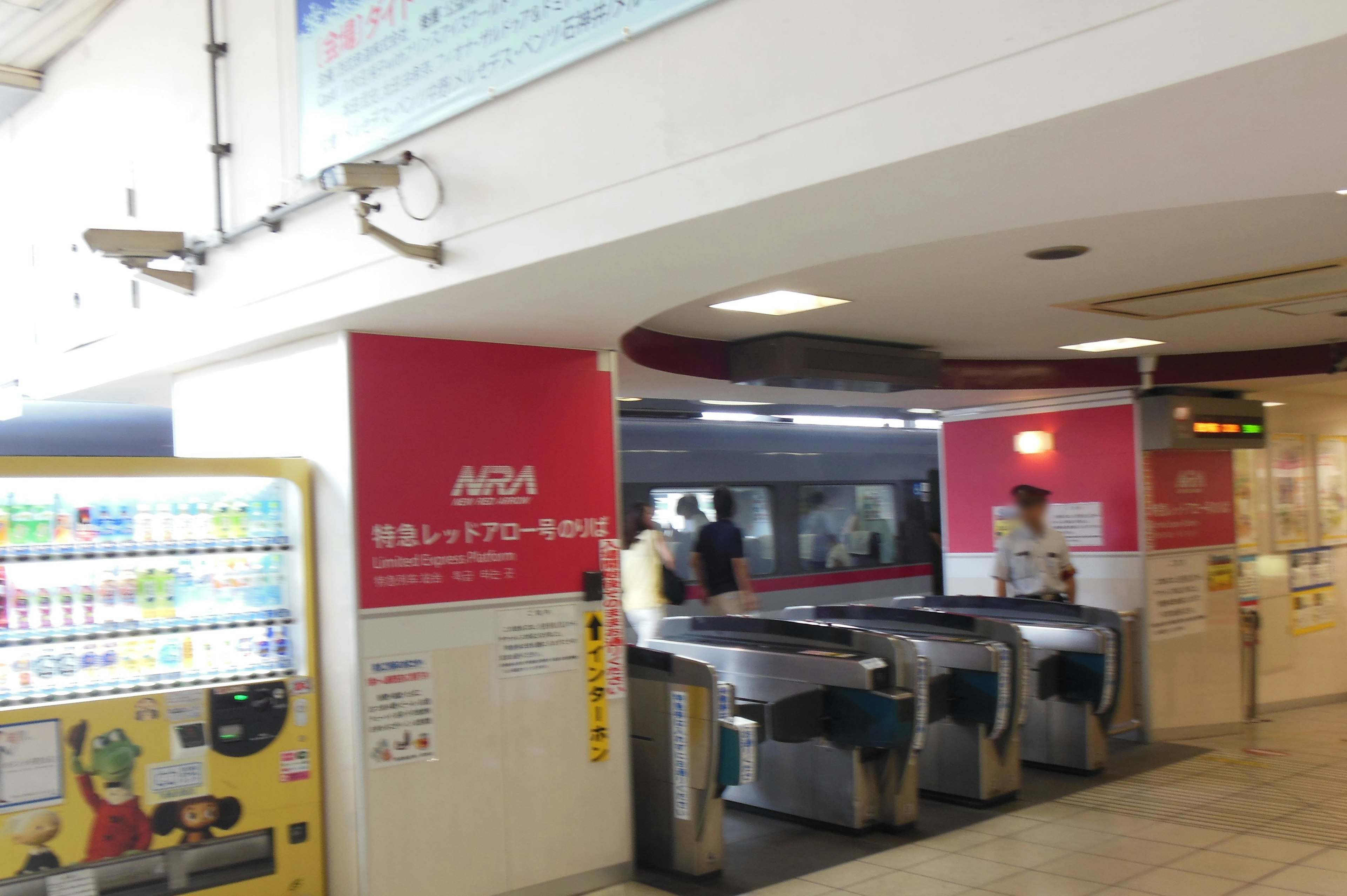 View of a train station ticket gate with a vending machine