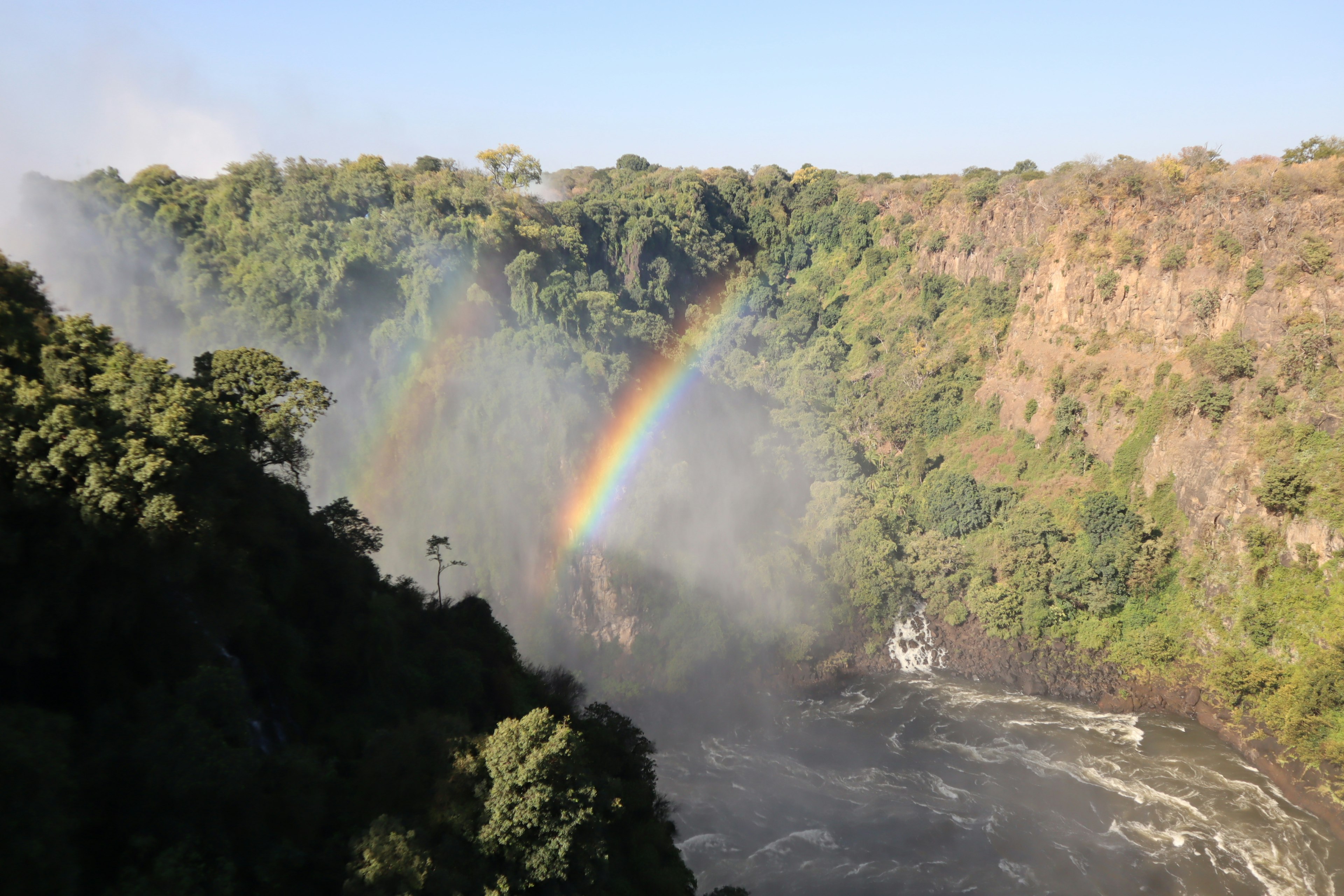 Victoria Falls showcasing a vibrant rainbow and lush greenery