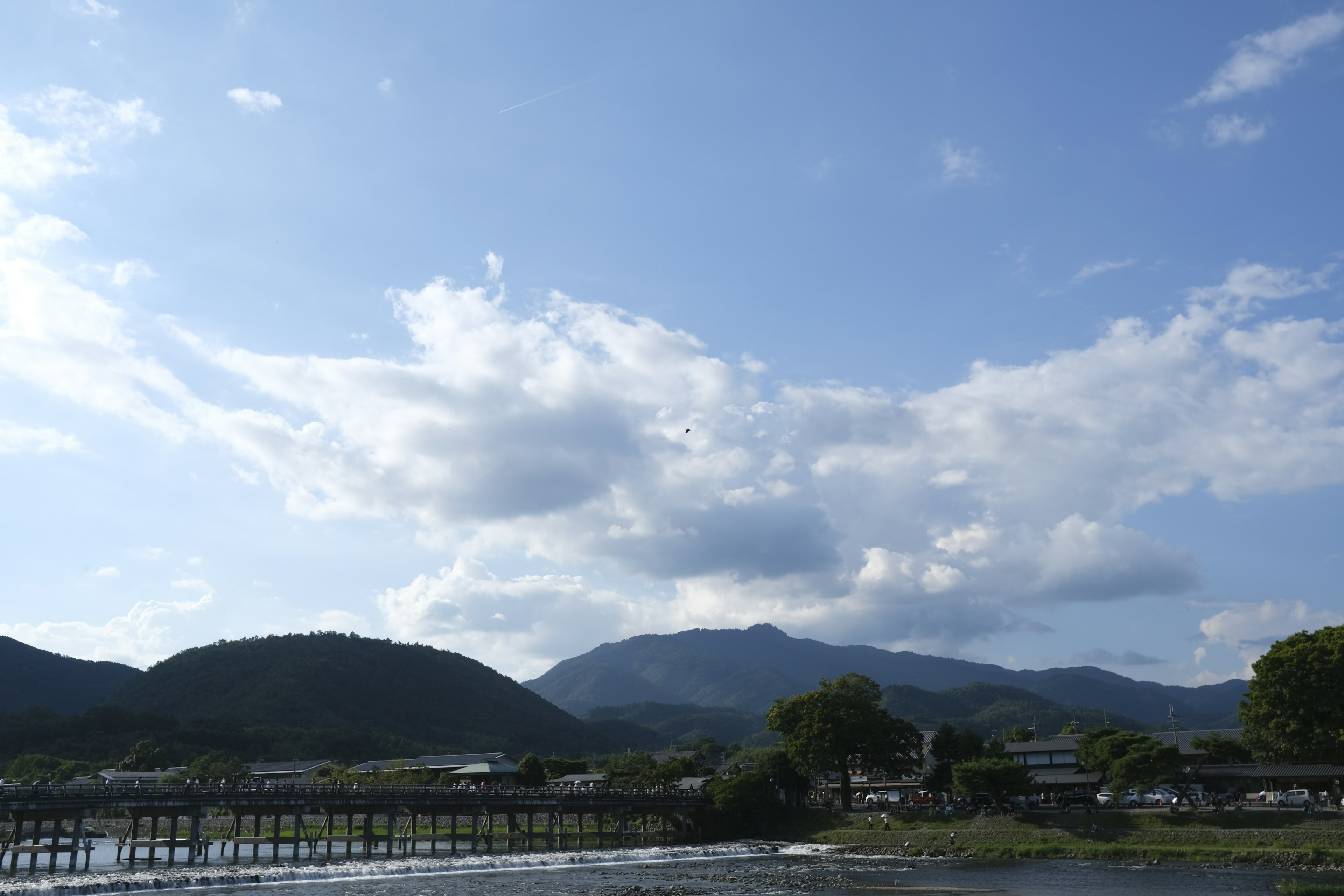 Vista panoramica delle montagne sotto un cielo blu con nuvole bianche