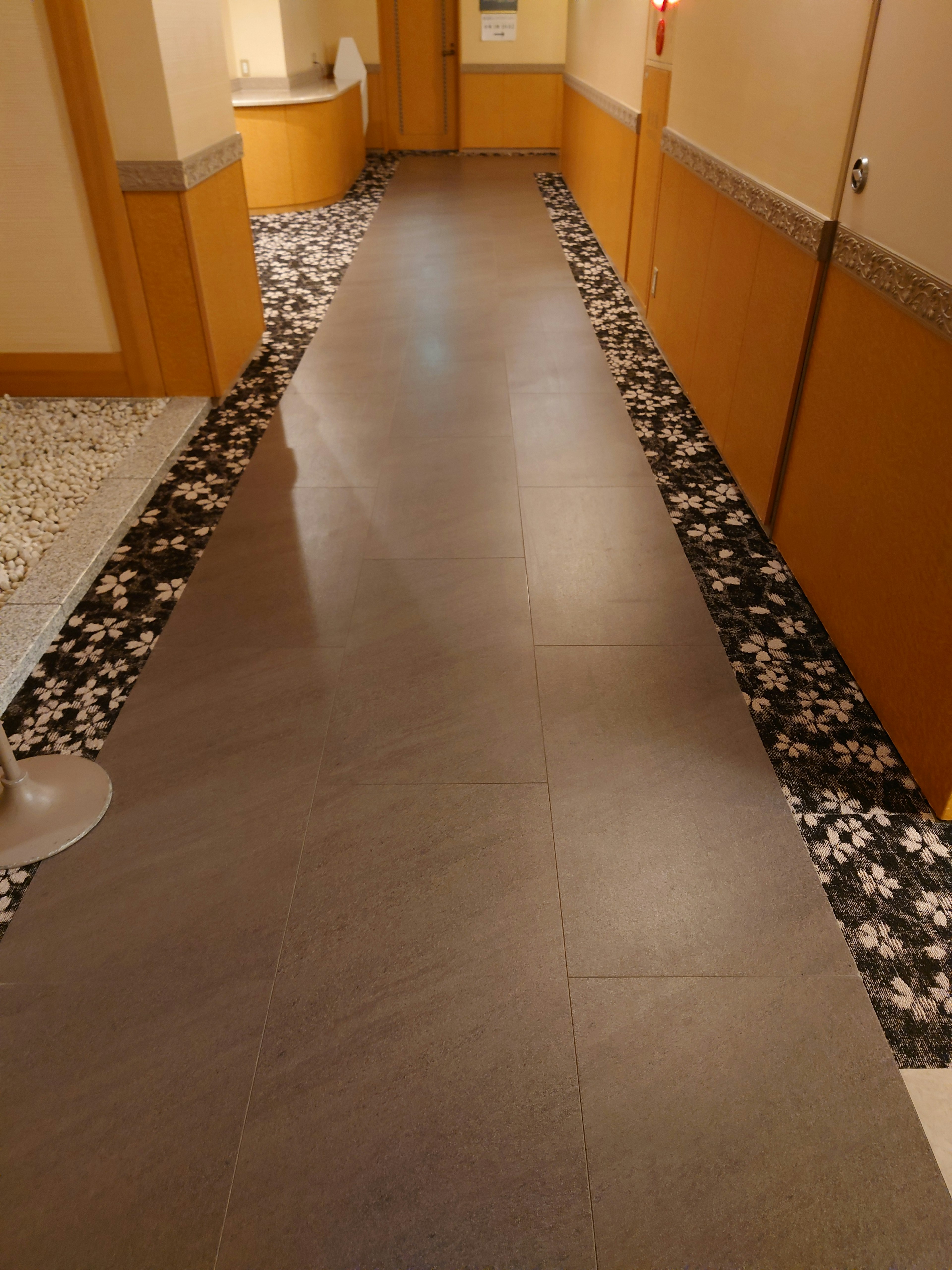 Stylish hallway featuring tile flooring and wooden walls