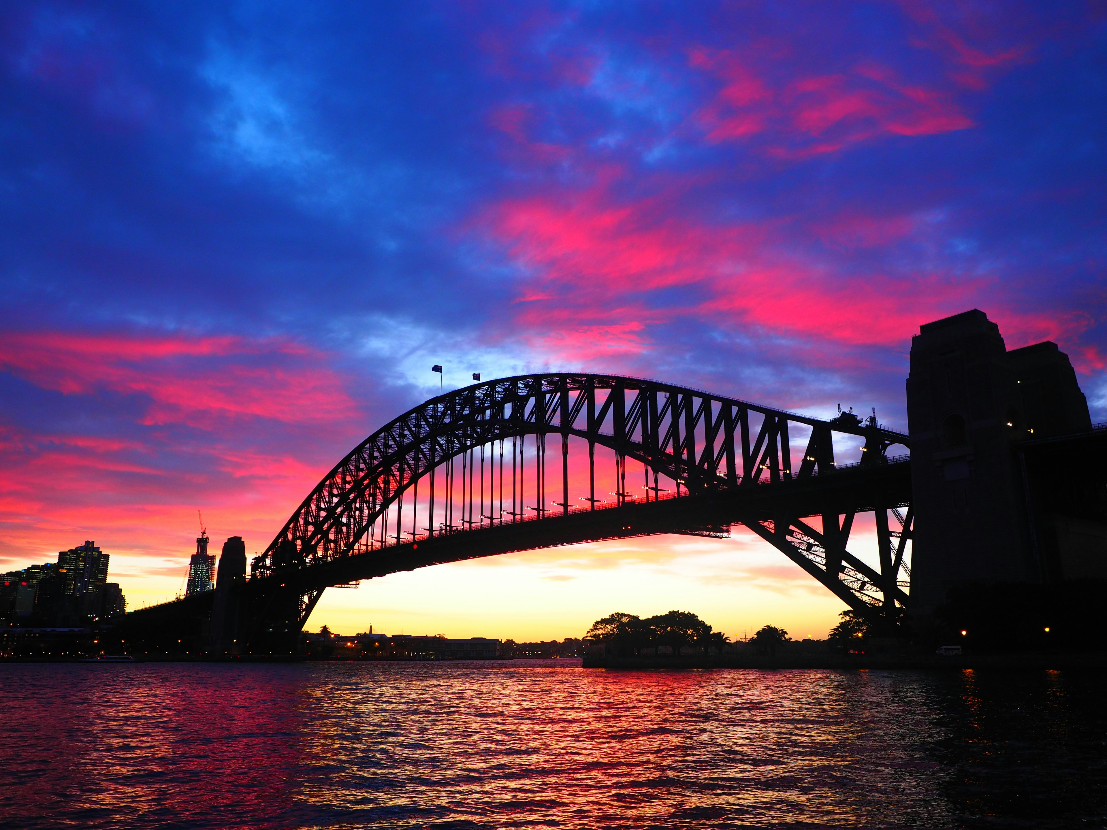 Ponte sul porto di Sydney in silhouette contro un tramonto vibrante