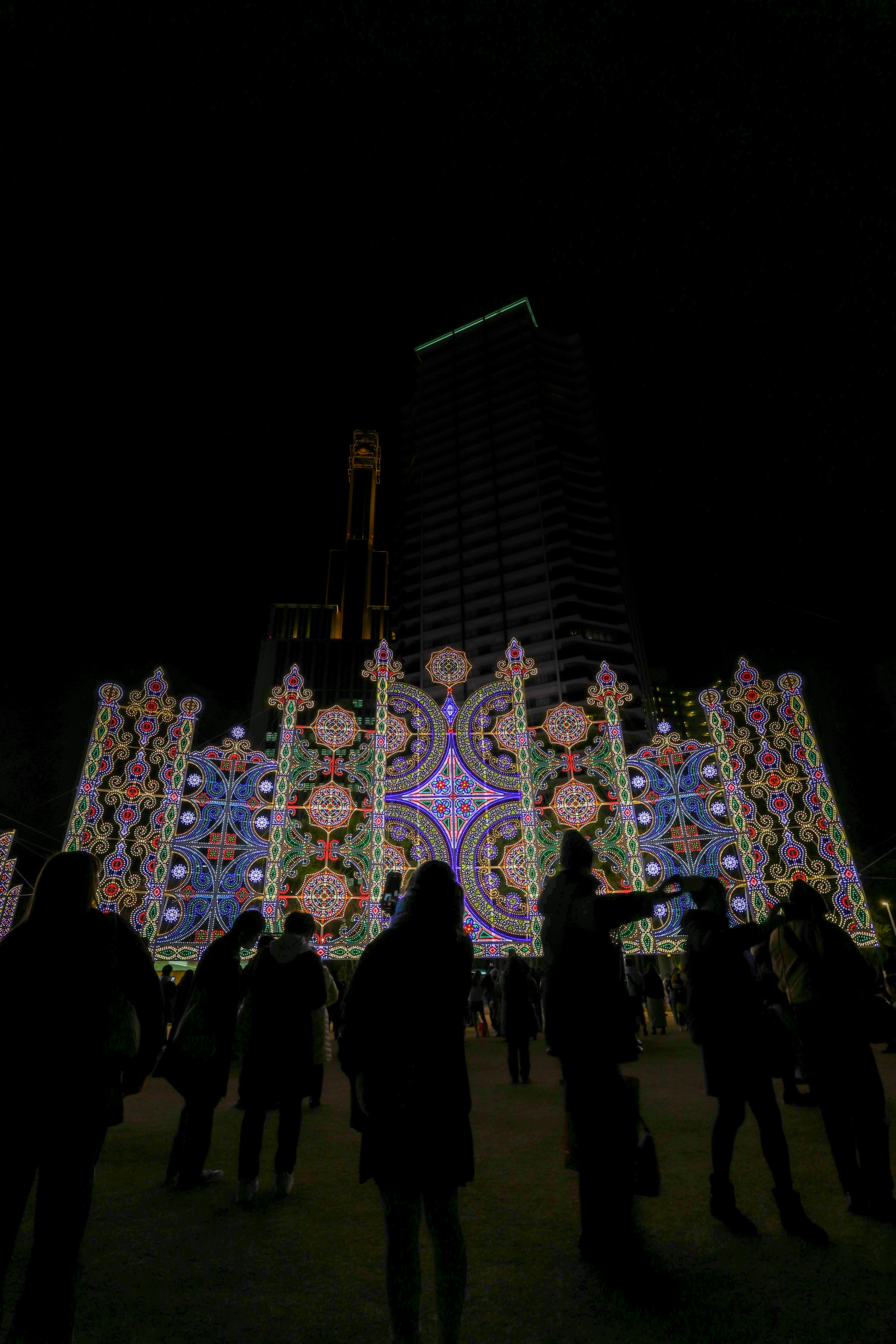 Bâtiment magnifiquement décoré illuminé la nuit avec des silhouettes de personnes