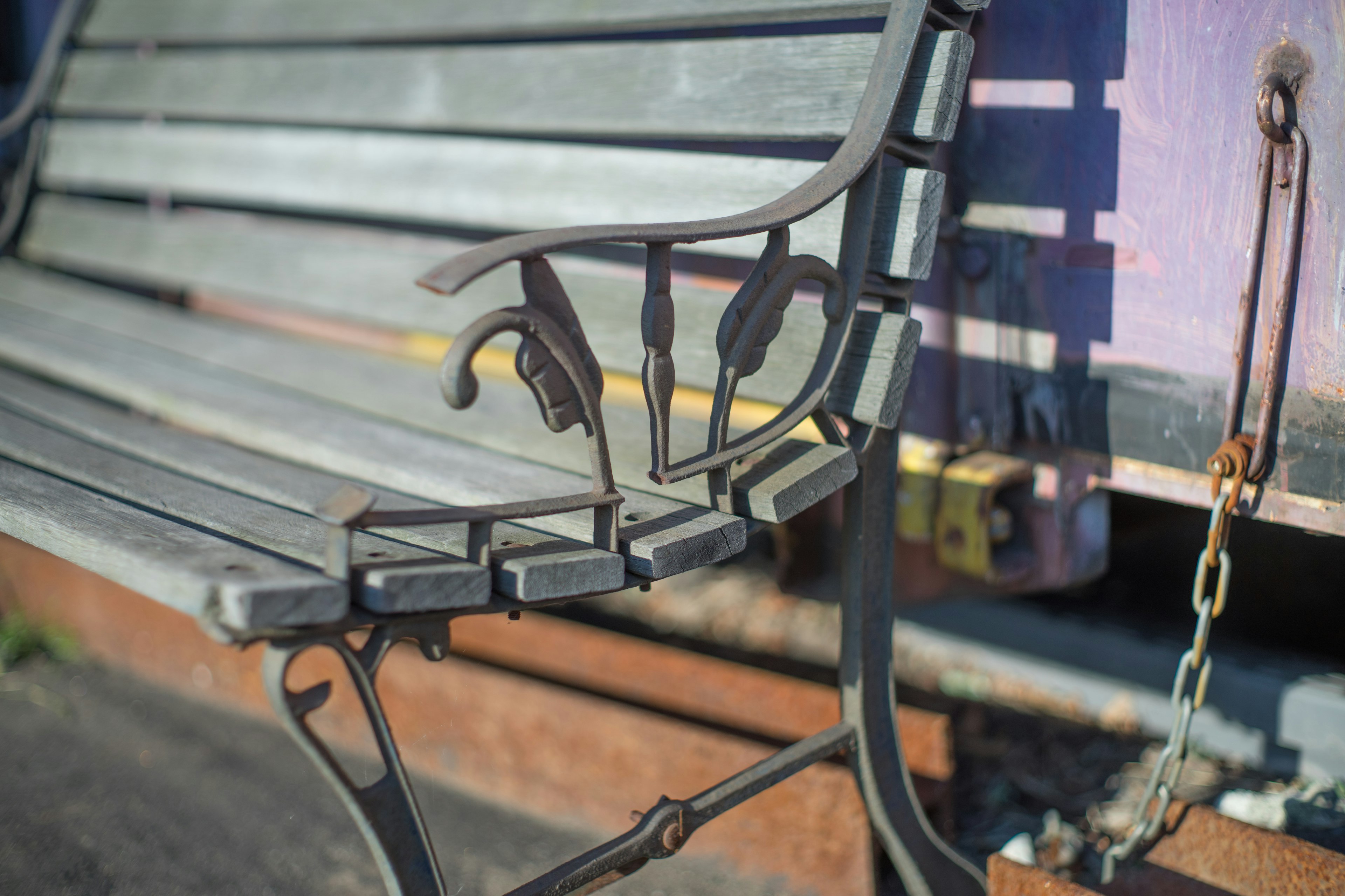 Primo piano di una panchina in legno con dettagli metallici intricati