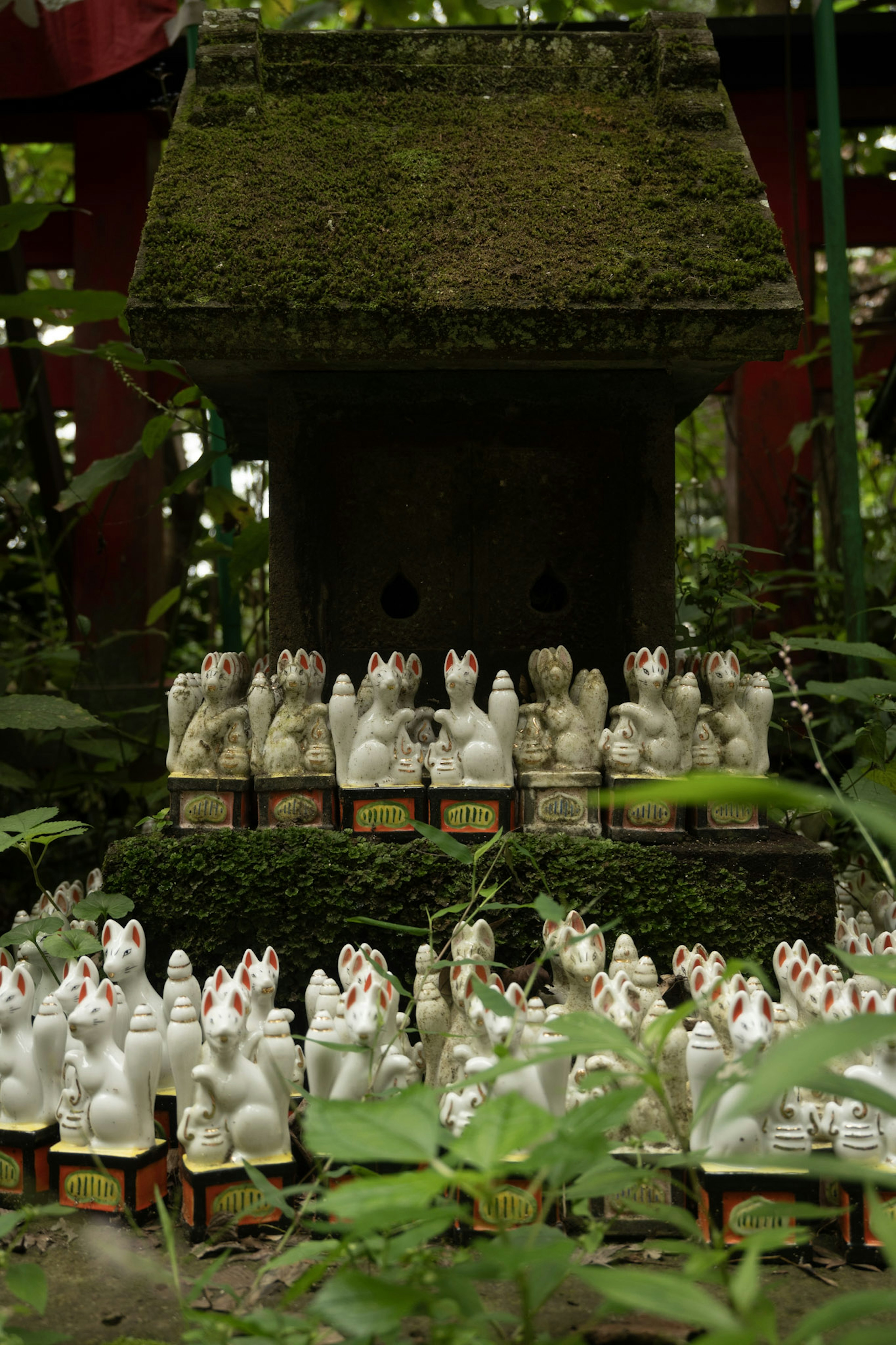 Una escena de santuario serena con filas de estatuas de conejos blancos rodeadas de vegetación