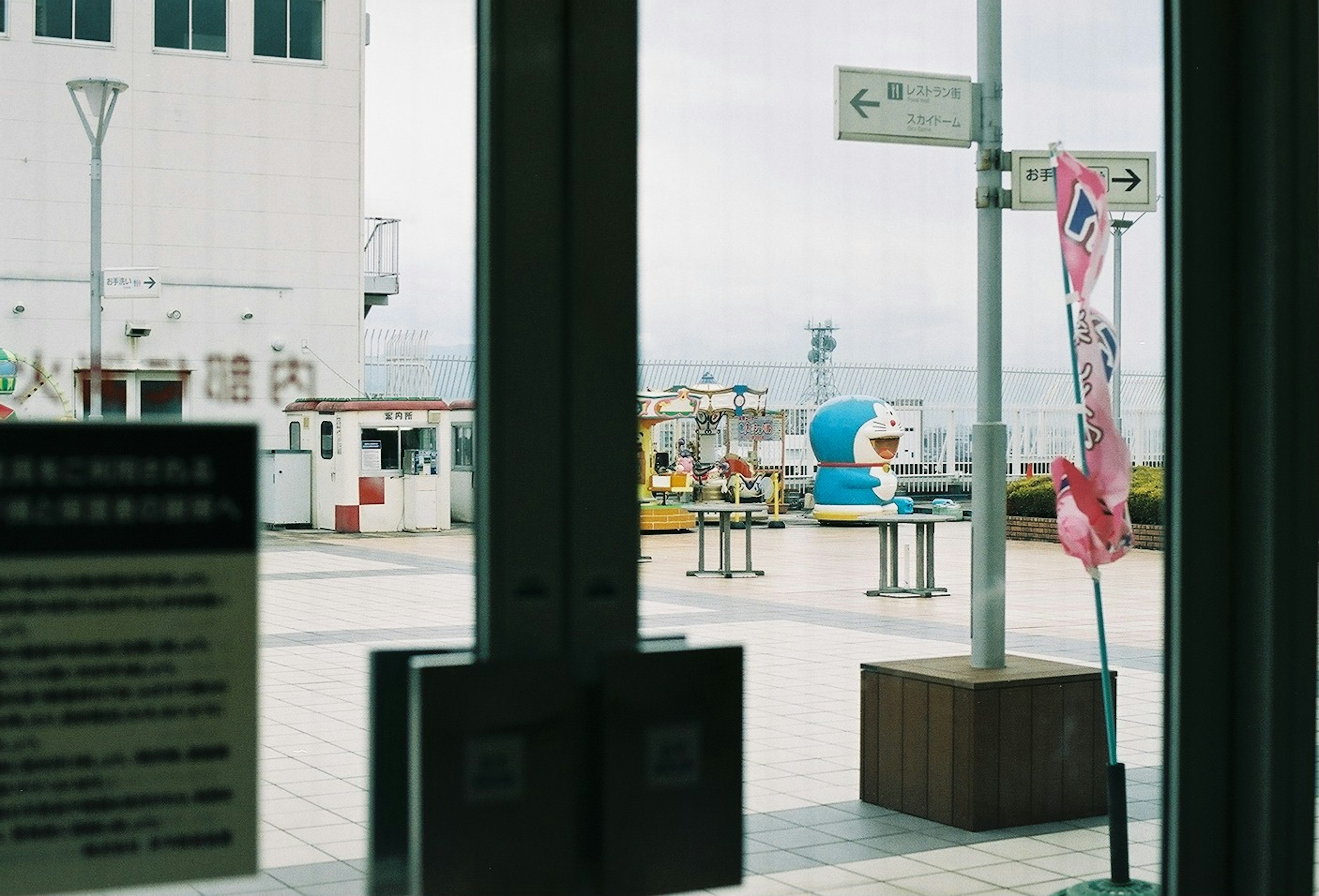 ドアの間から見える屋外の風景と遊具のある公園