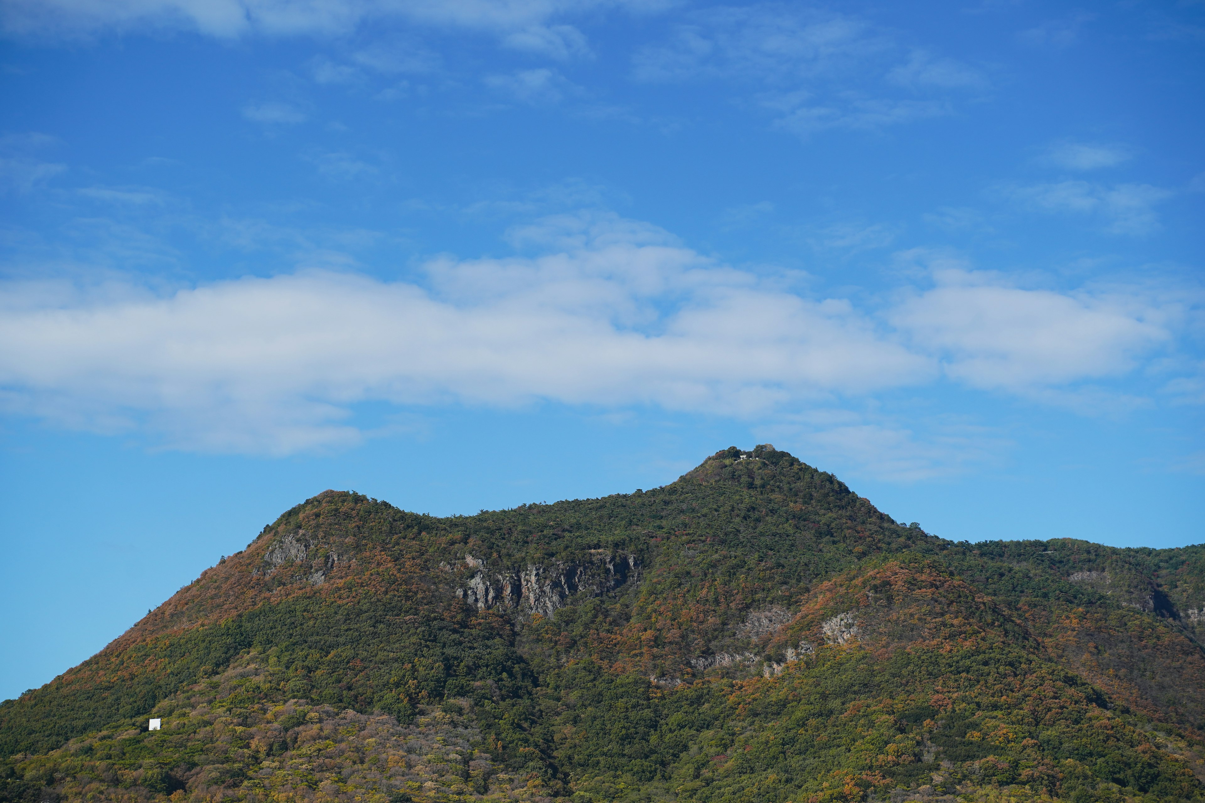 Montagne verdi sotto un cielo blu con nuvole