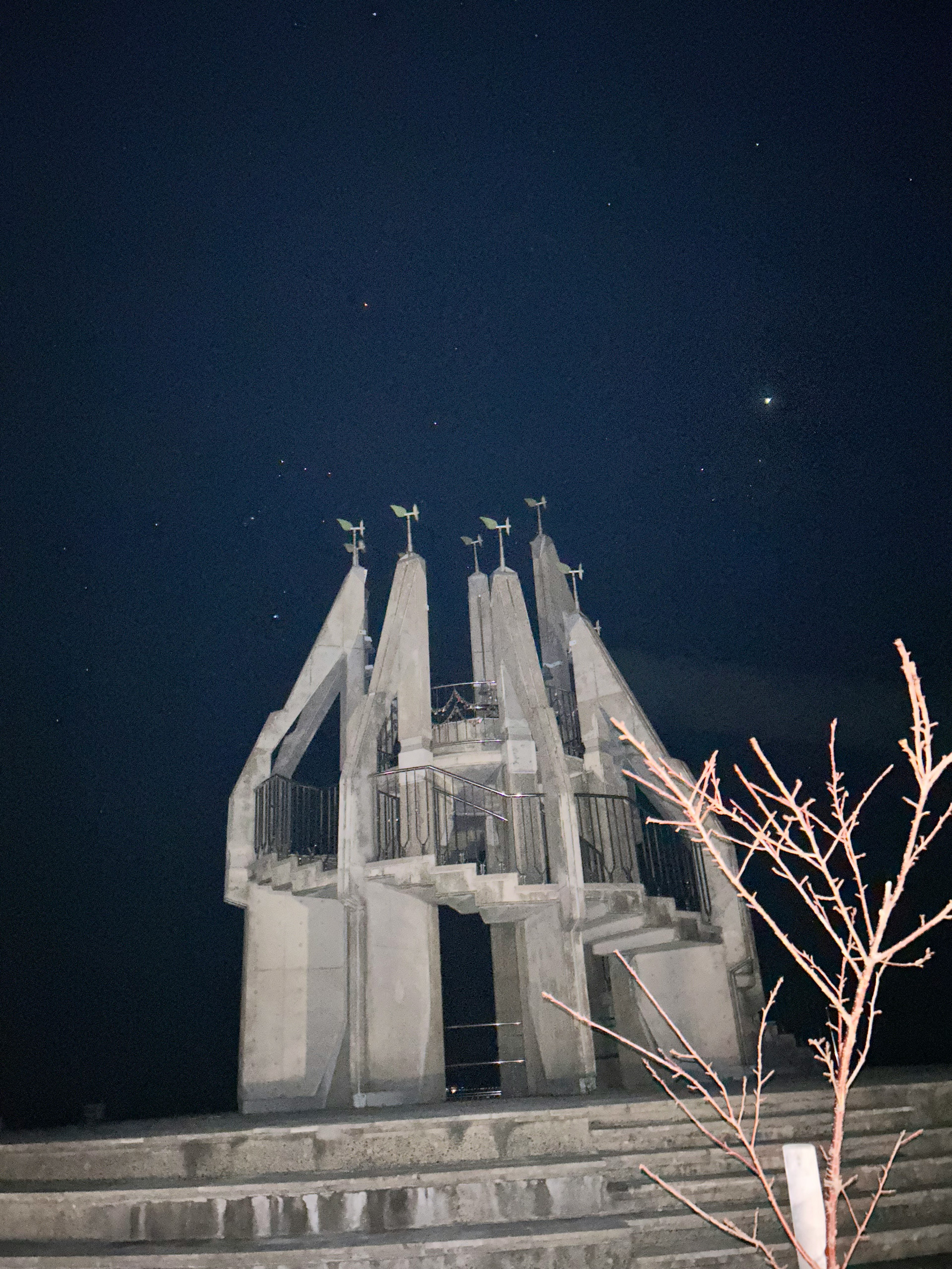 夜空に浮かぶモダンな彫刻と星々が見える風景