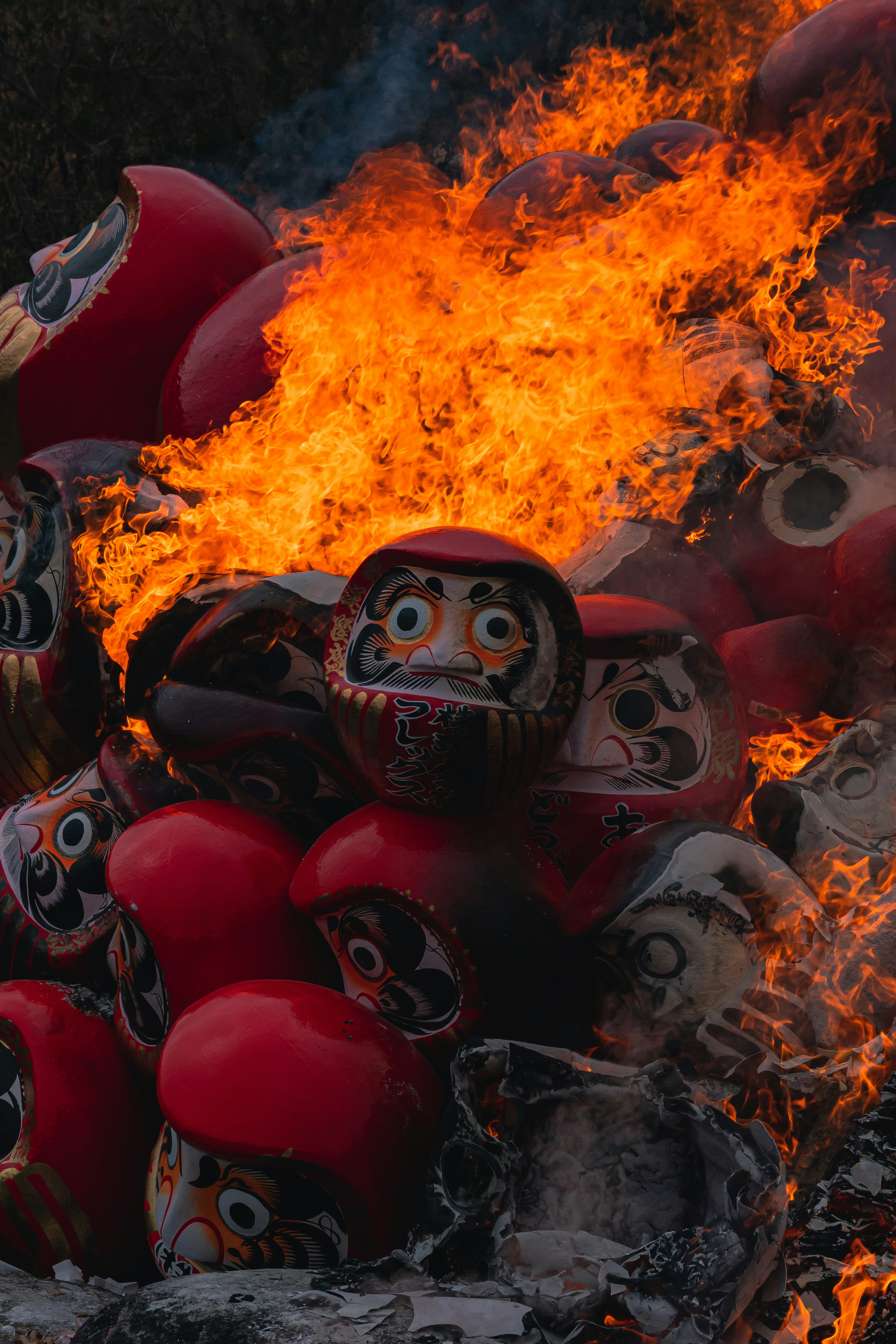 Una pila di bambole Daruma avvolte dalle fiamme