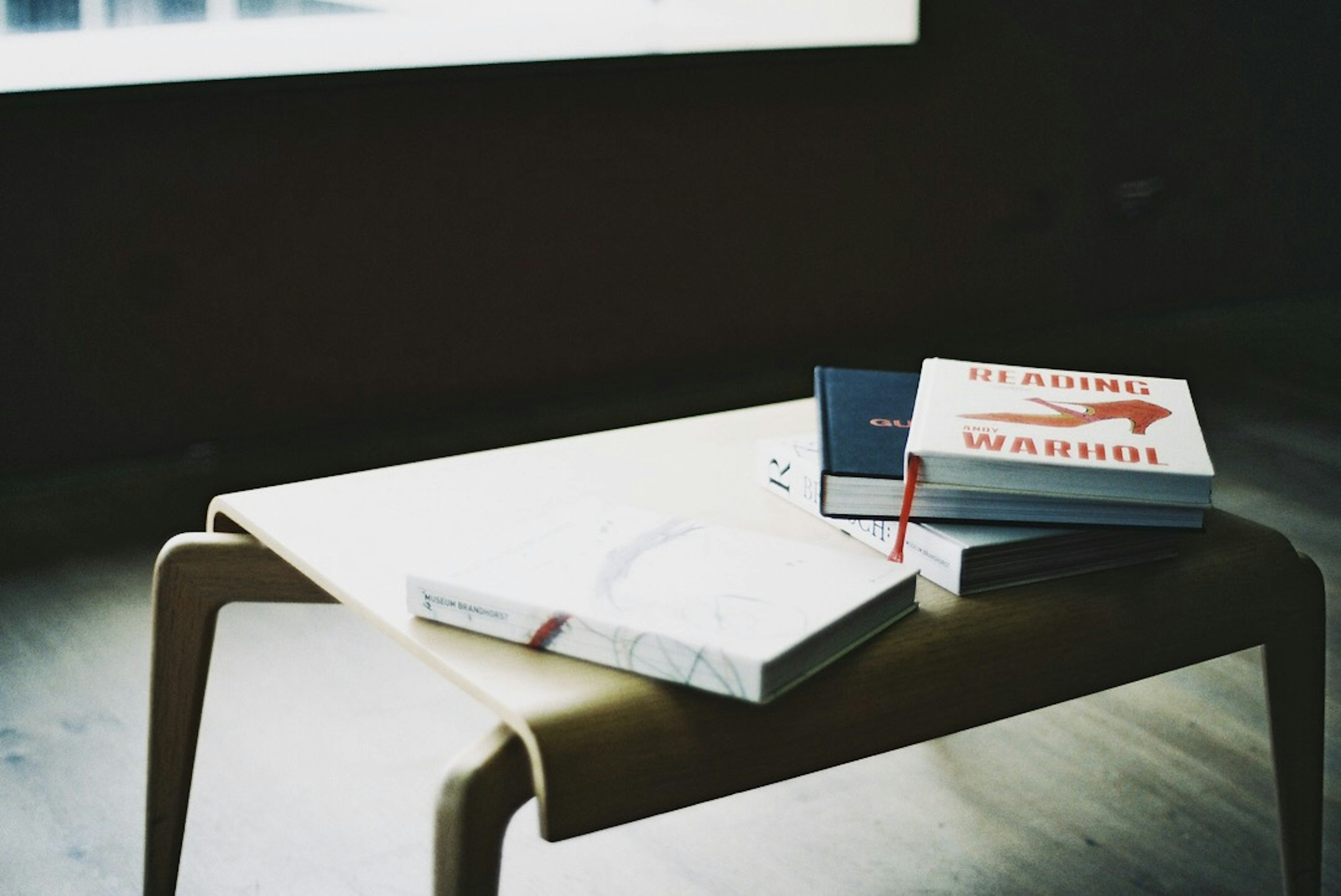 Stack of books and a notebook on a wooden table