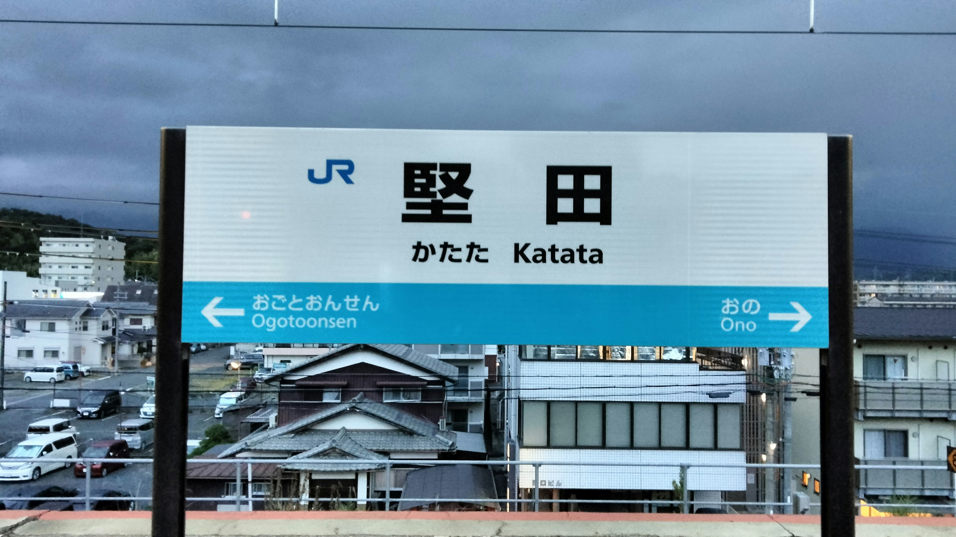 Panneau de la gare JR Katata avec des bâtiments environnants