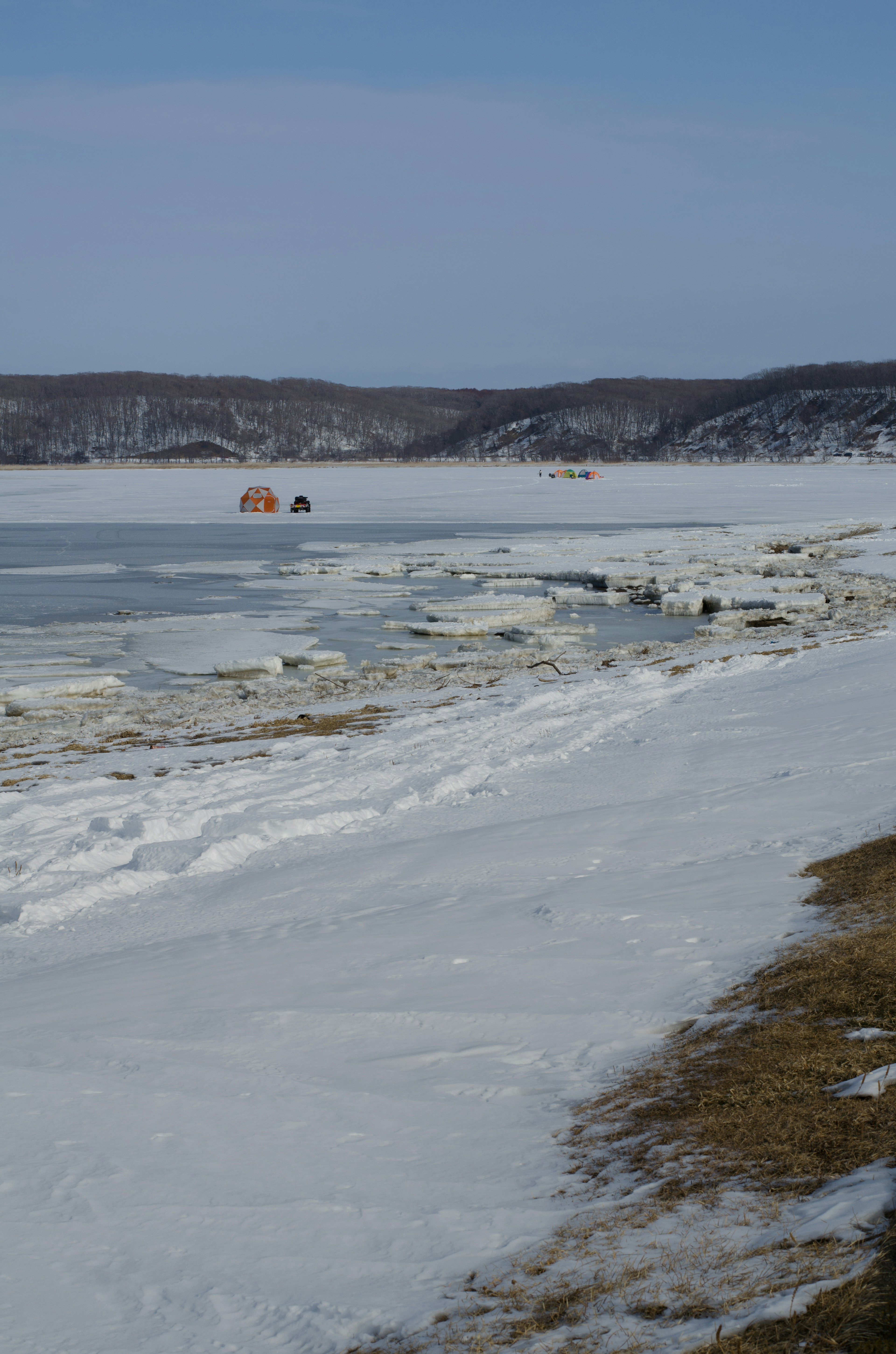 Frozen lake shore with ice and snow landscape