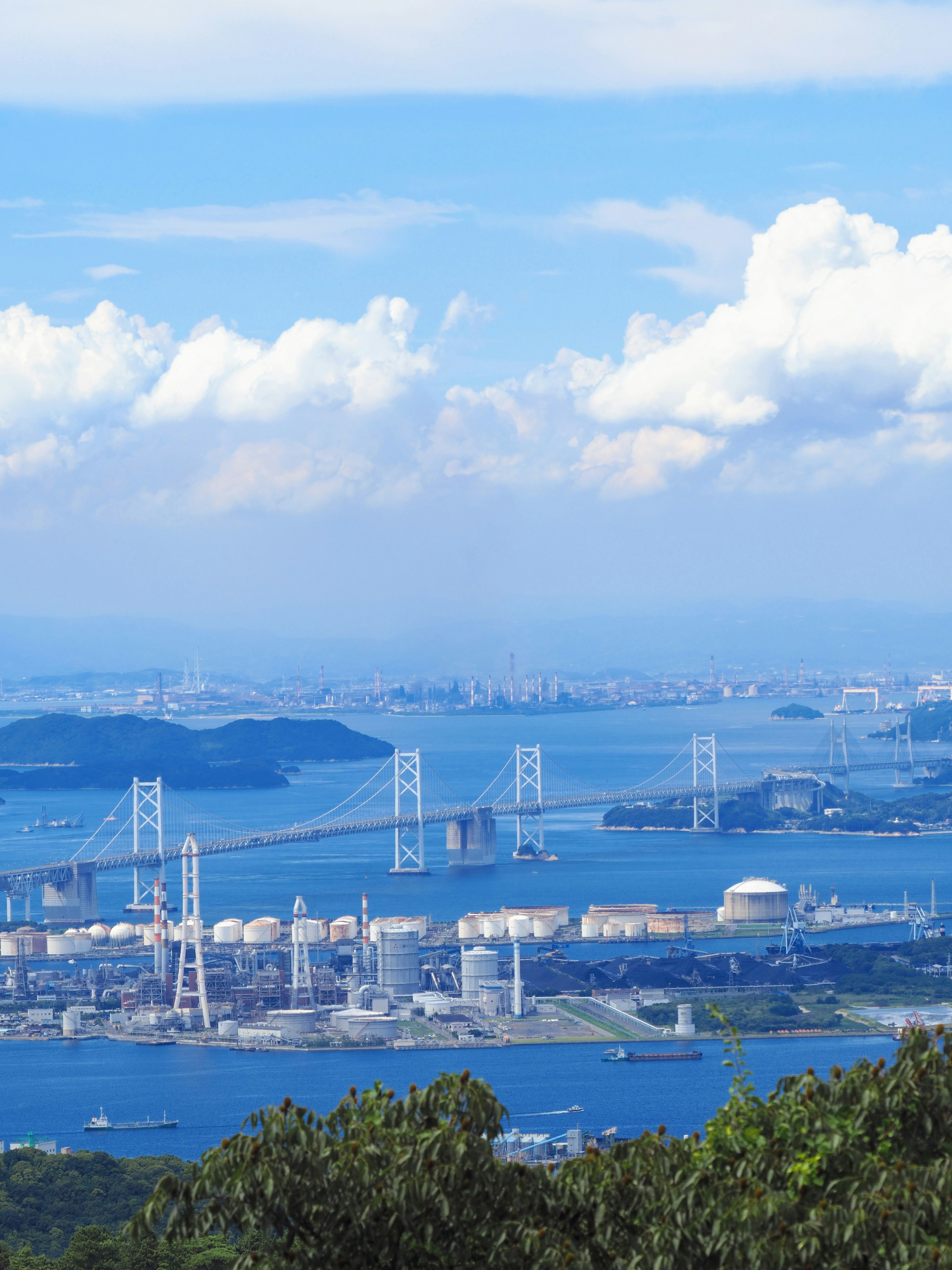 Scenic view of a blue sky with clouds over water and bridges