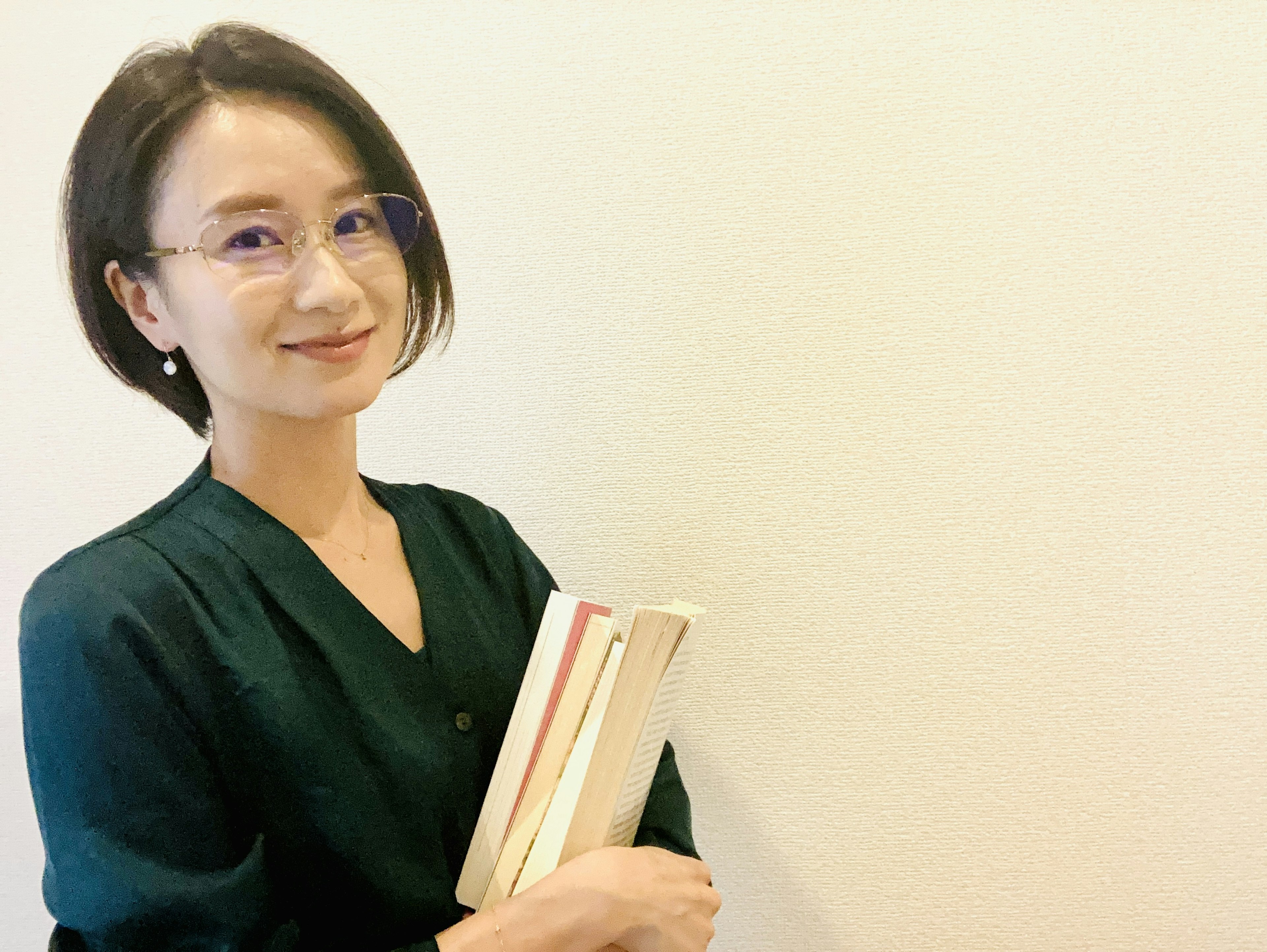 Una mujer sonriendo mientras sostiene libros