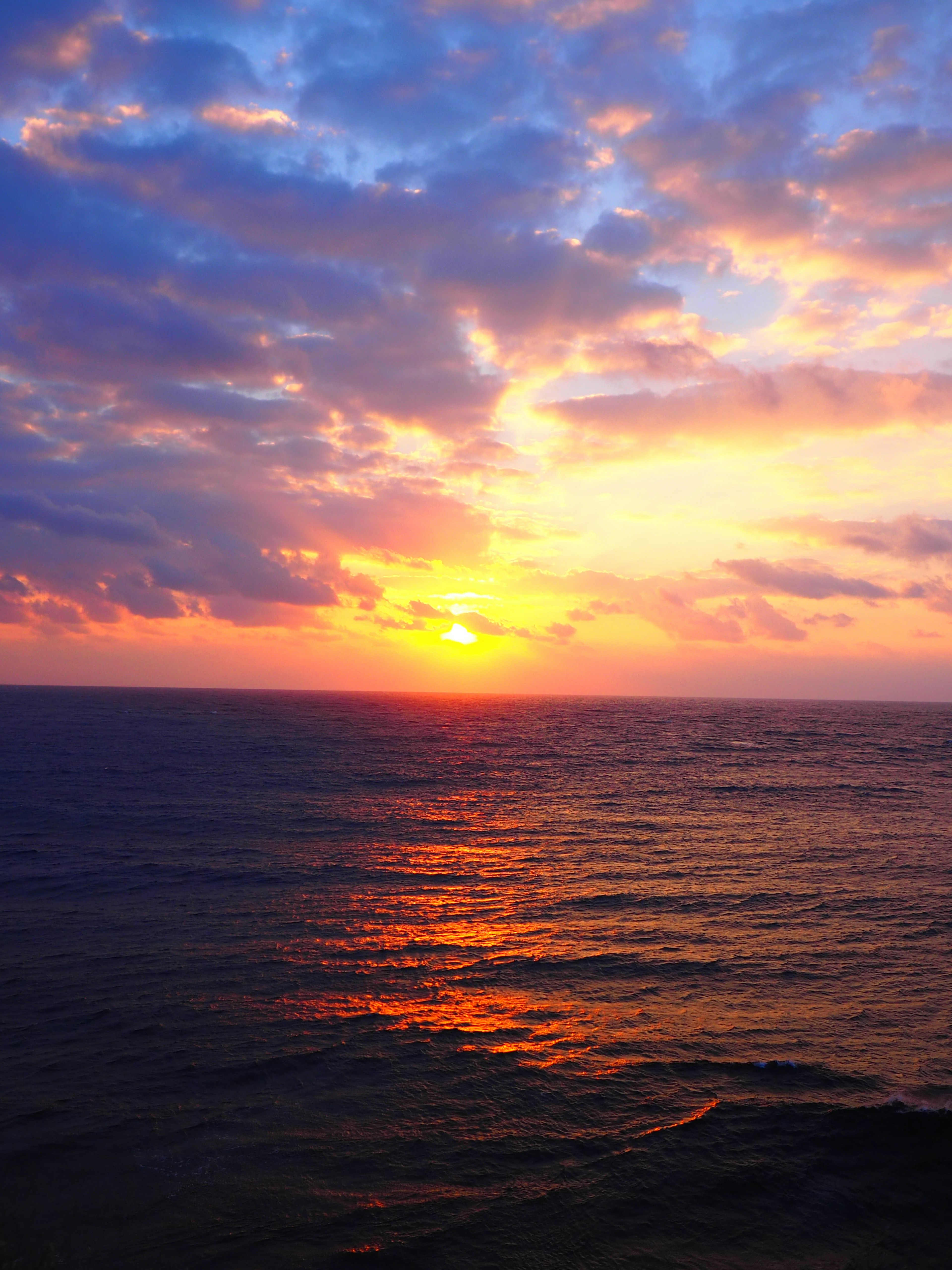 Un bellissimo tramonto sull'oceano con nuvole arancioni e viola