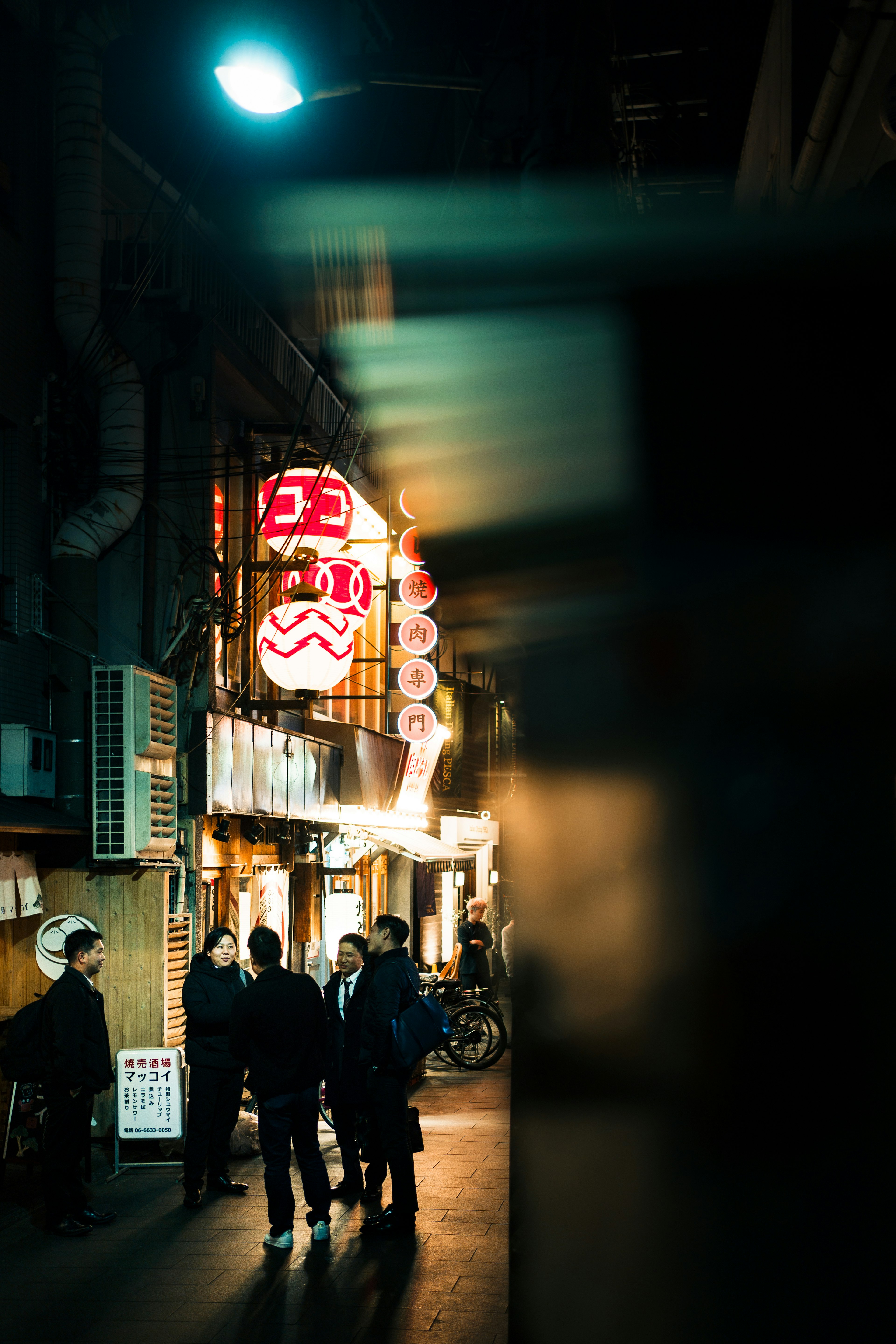 Night street scene with people gathering in a dimly lit alley