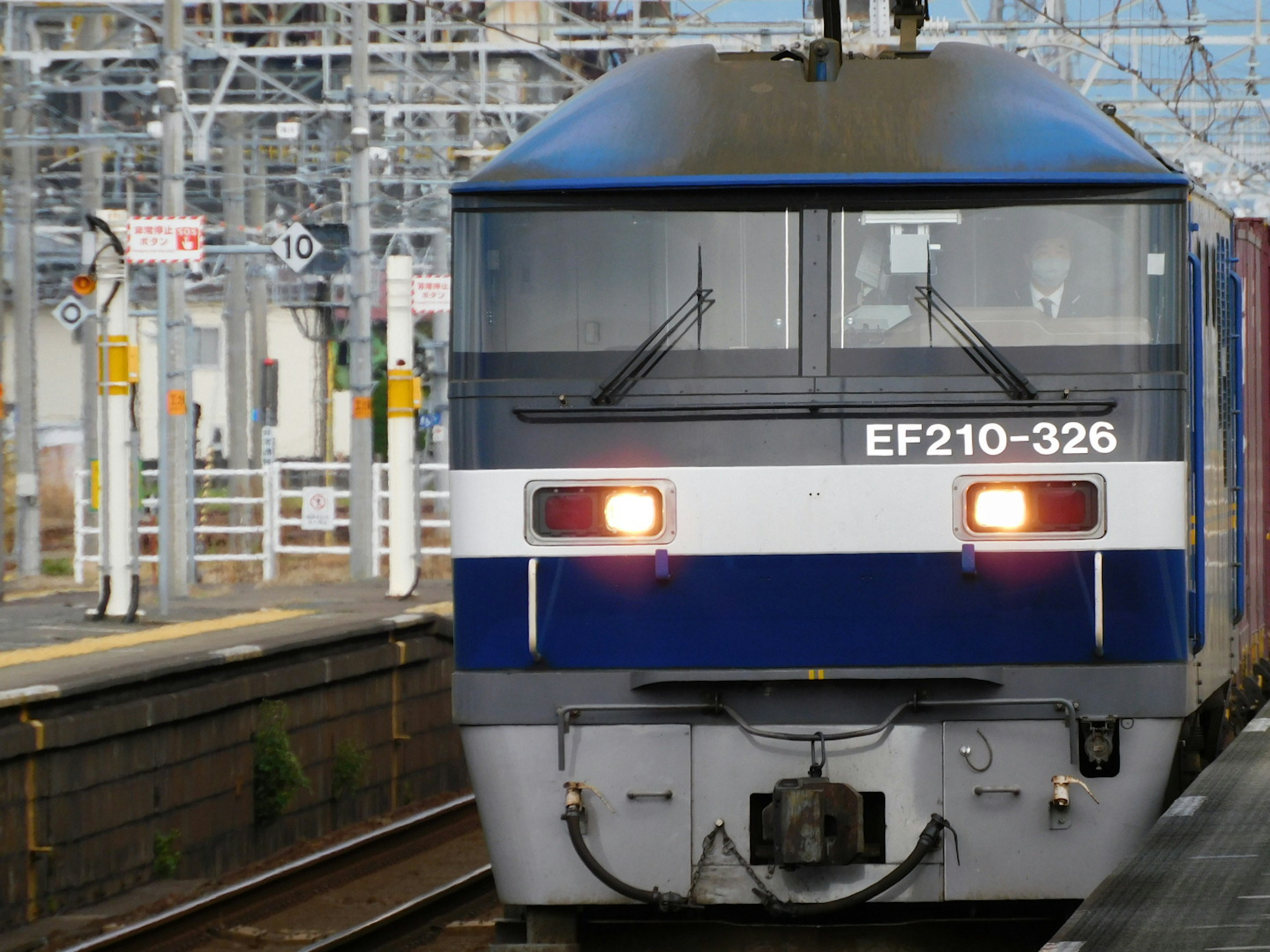 Blue EF210-326 electric locomotive stopping at a train station