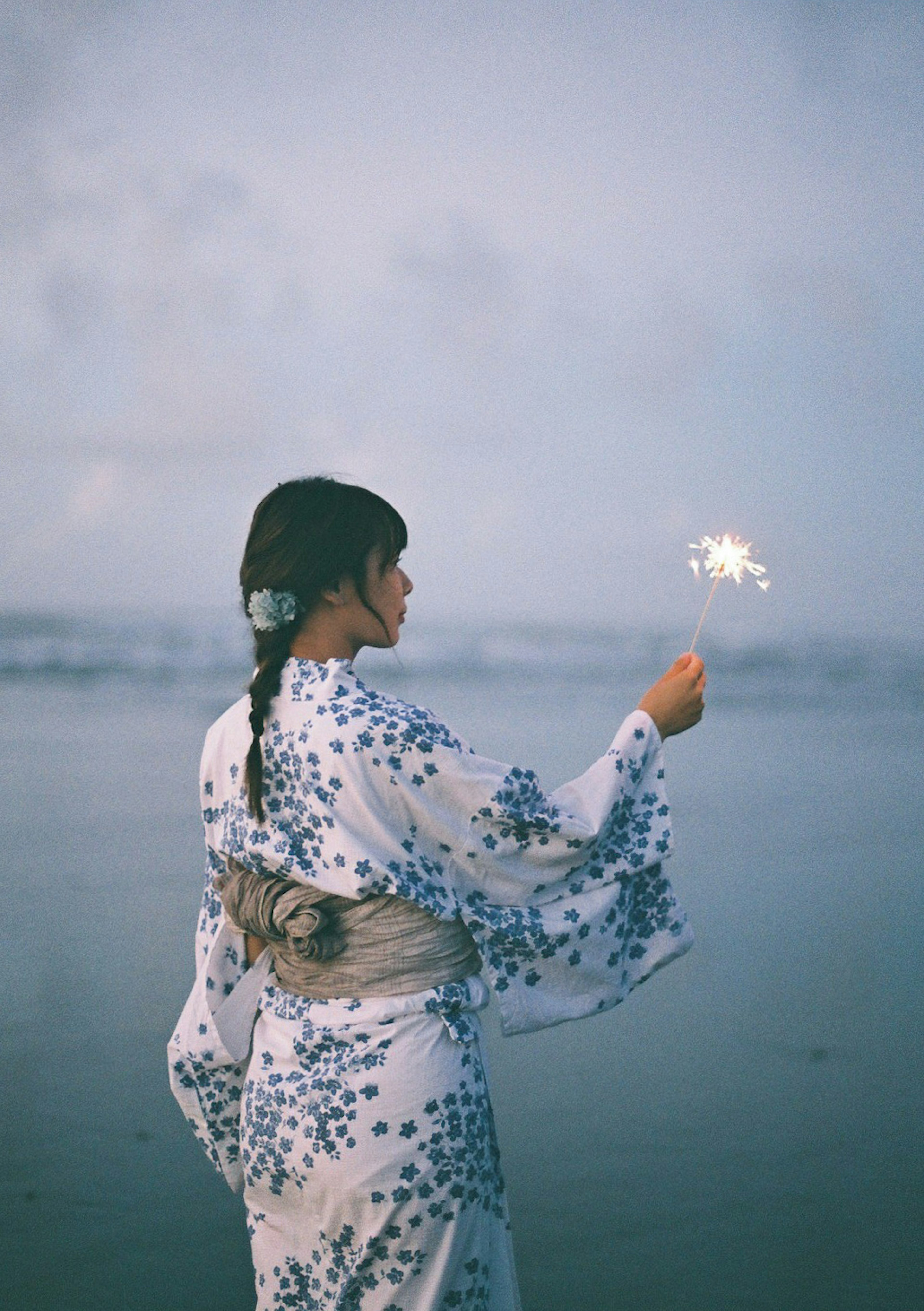 海辺で花火を持つ着物を着た女性