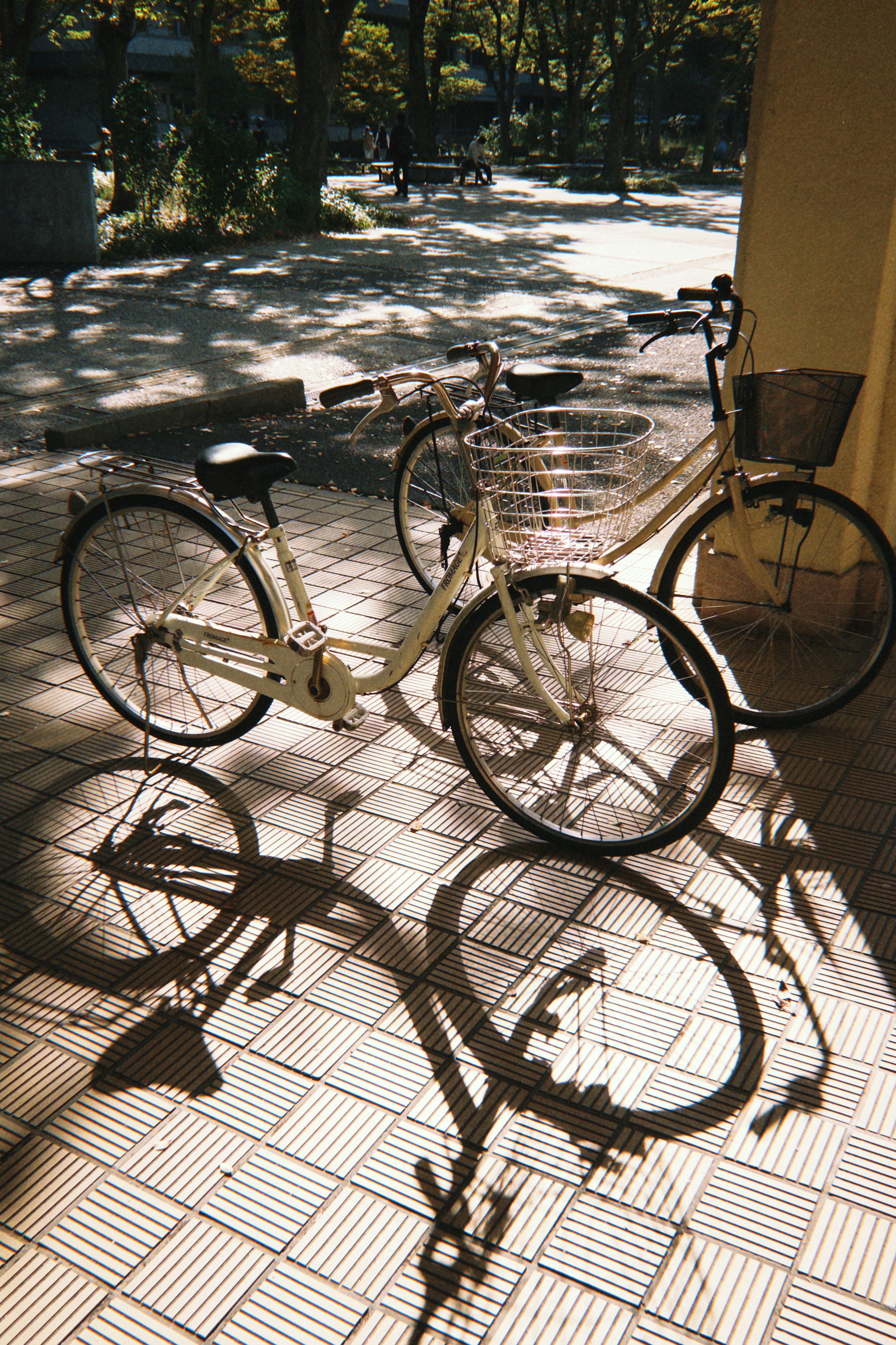 Una bicicletta bianca che proietta un'ombra su un marciapiede piastrellato