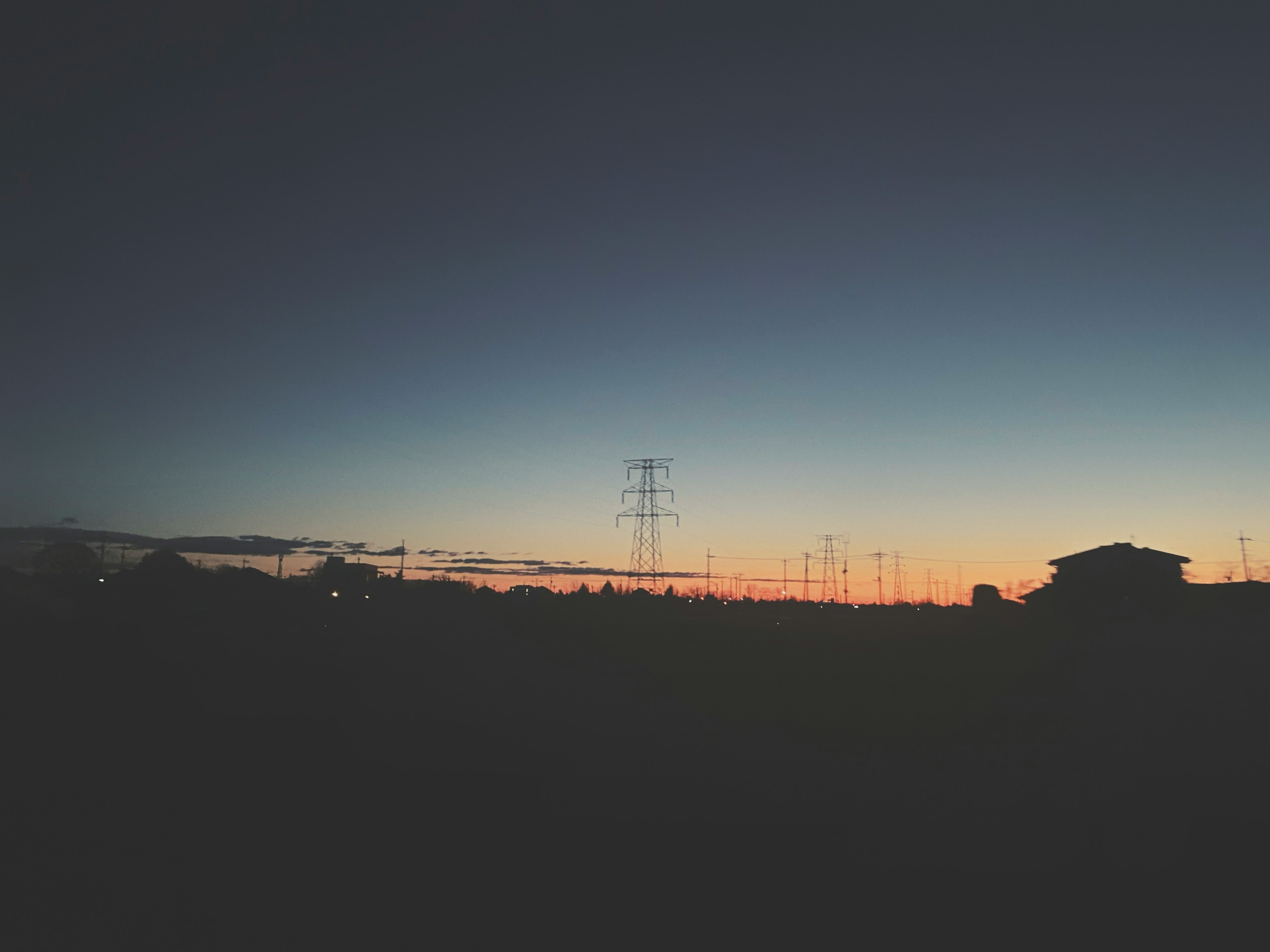 Silueta de líneas eléctricas contra un cielo colorido al atardecer