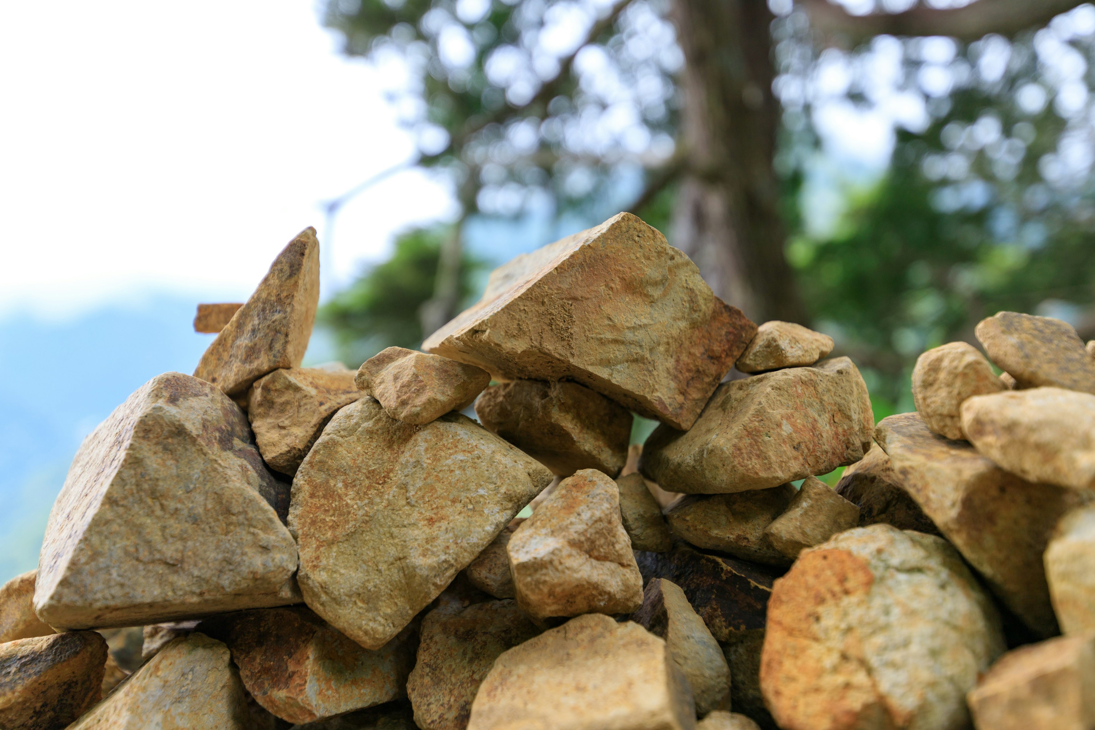 Close-up of stacked rocks with trees in the background