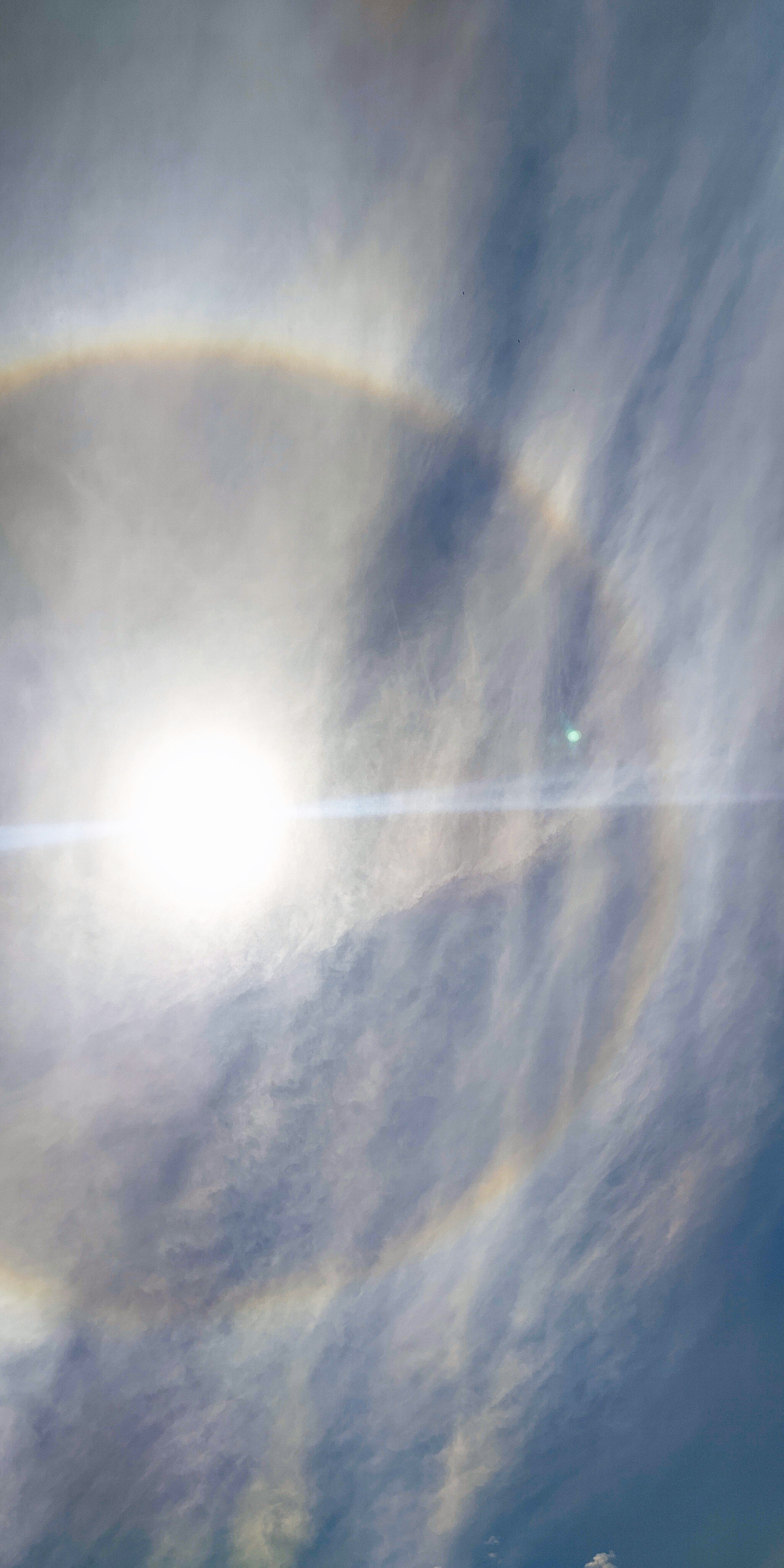 Soleil brillant entouré d'halos colorés dans le ciel