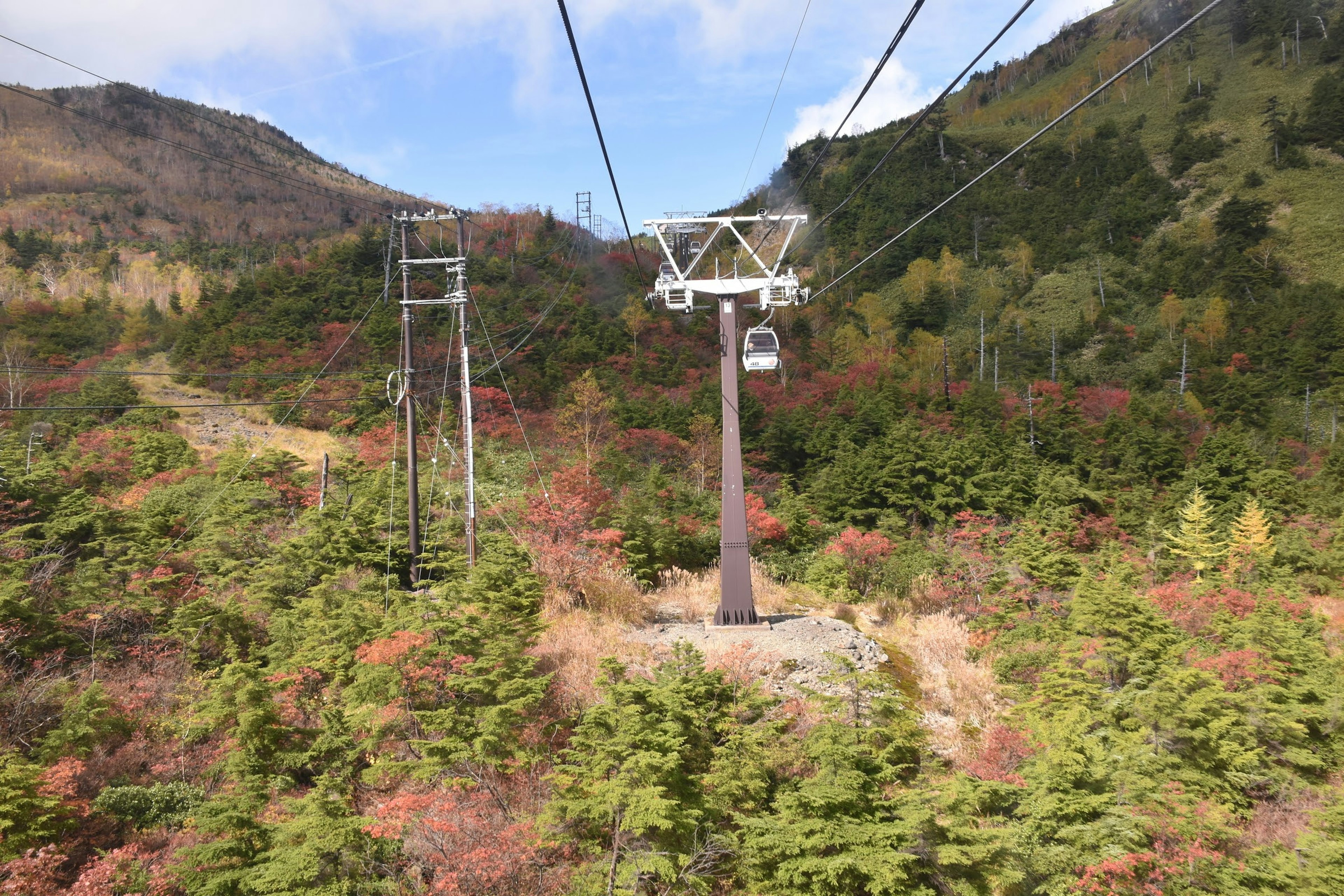 A cable car in the mountains surrounded by autumn foliage