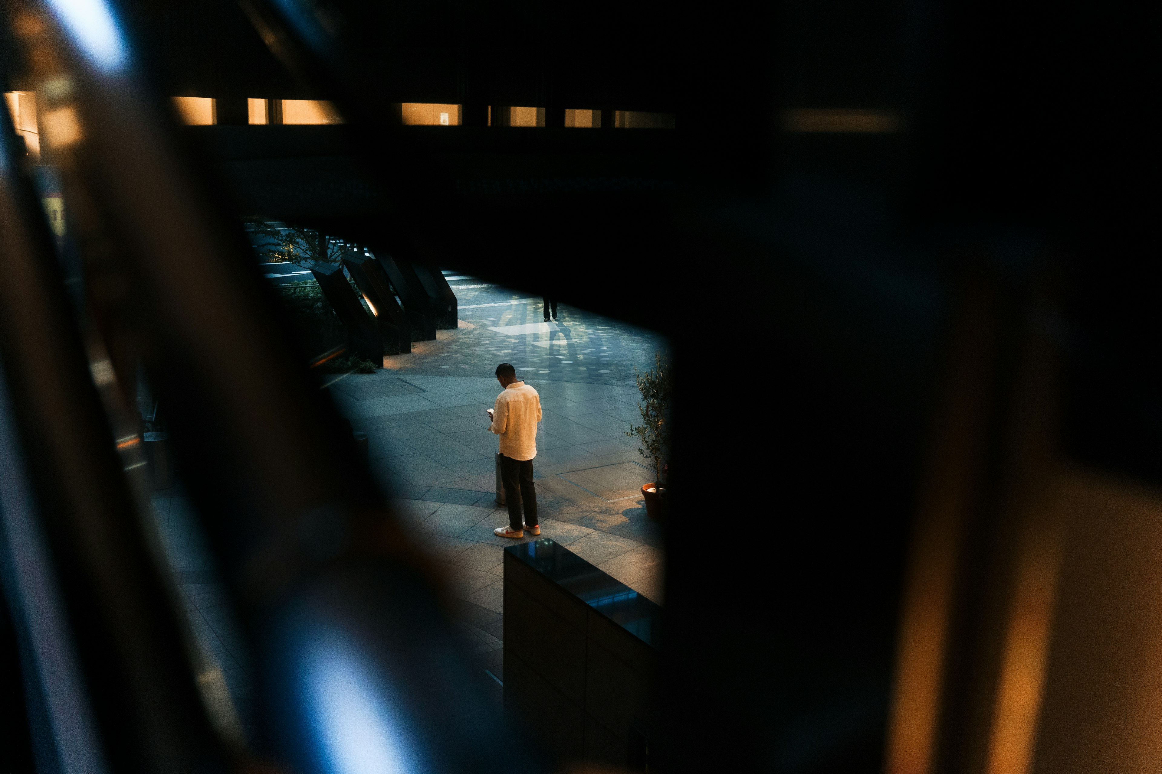 A person standing in a dimly lit street surrounded by cars