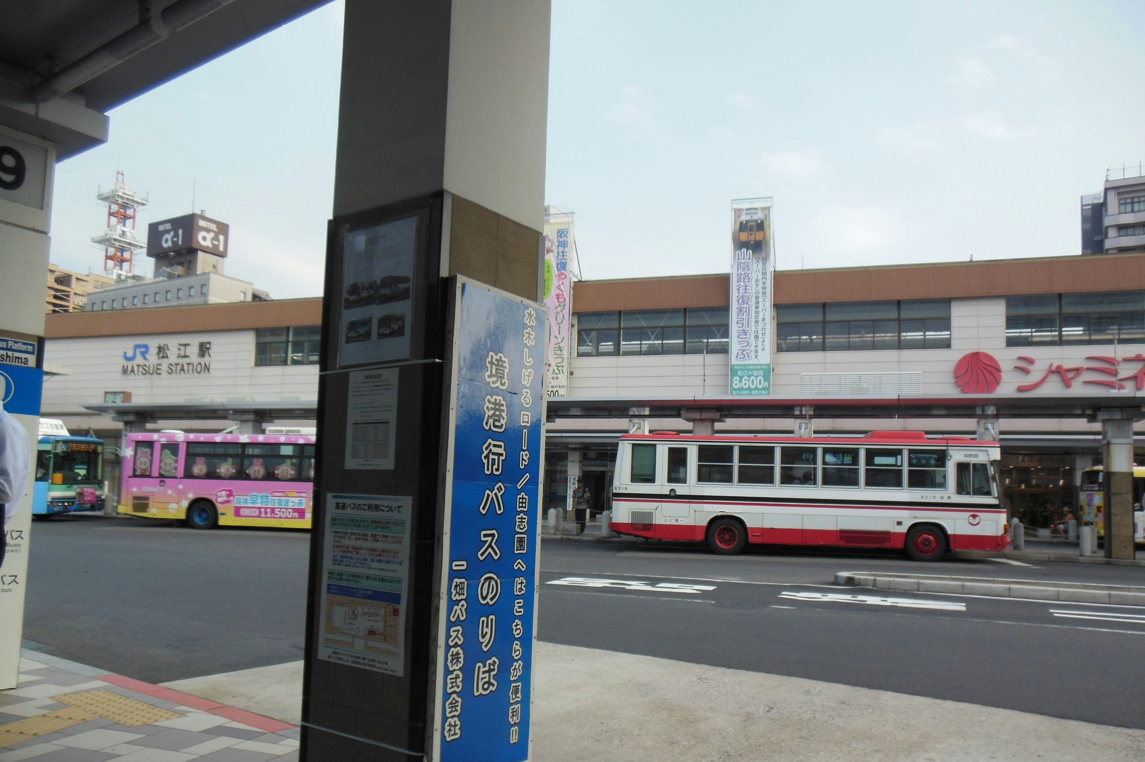 View of a bus stop with buses parked outside a station