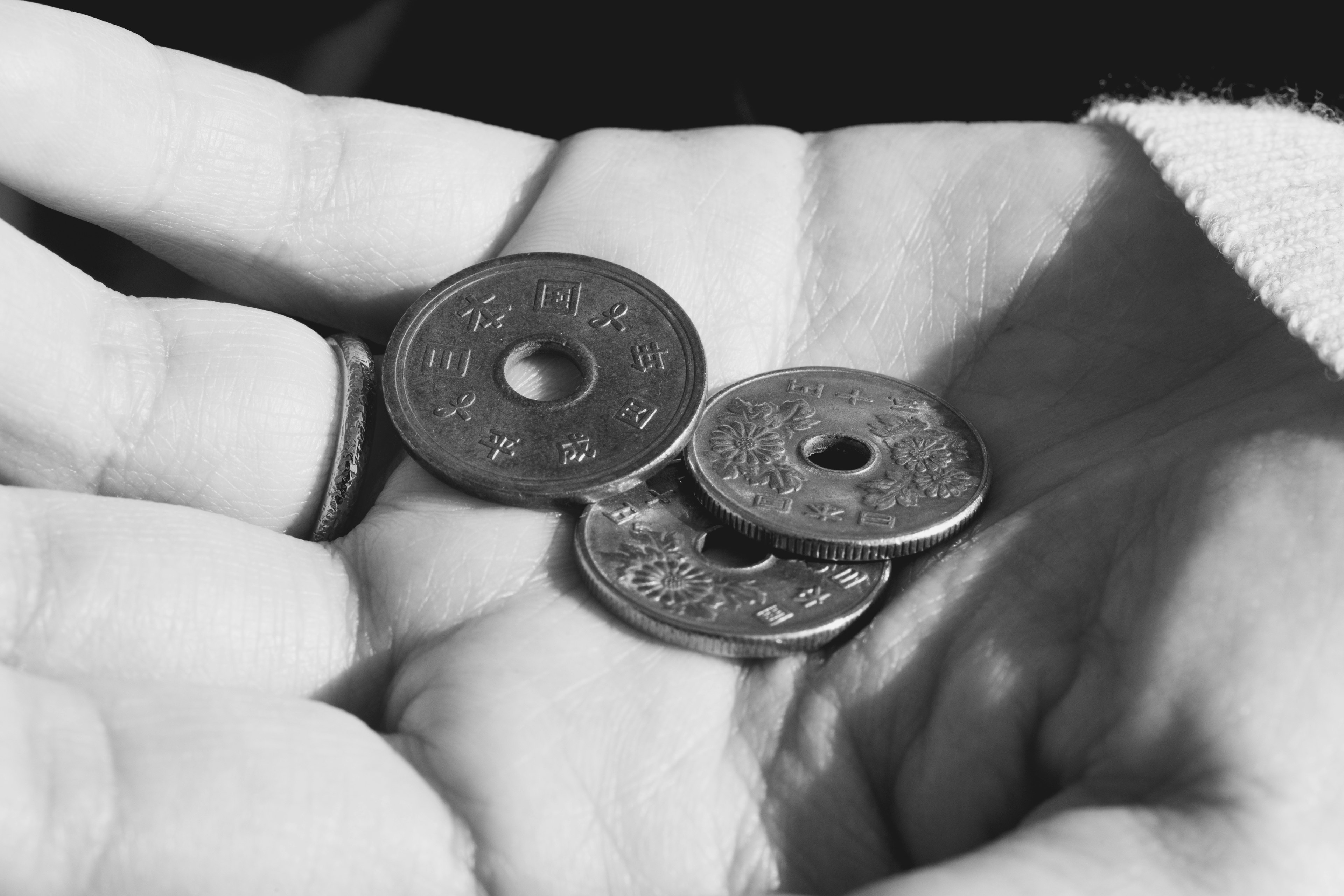 Tres monedas antiguas descansando en una mano abierta