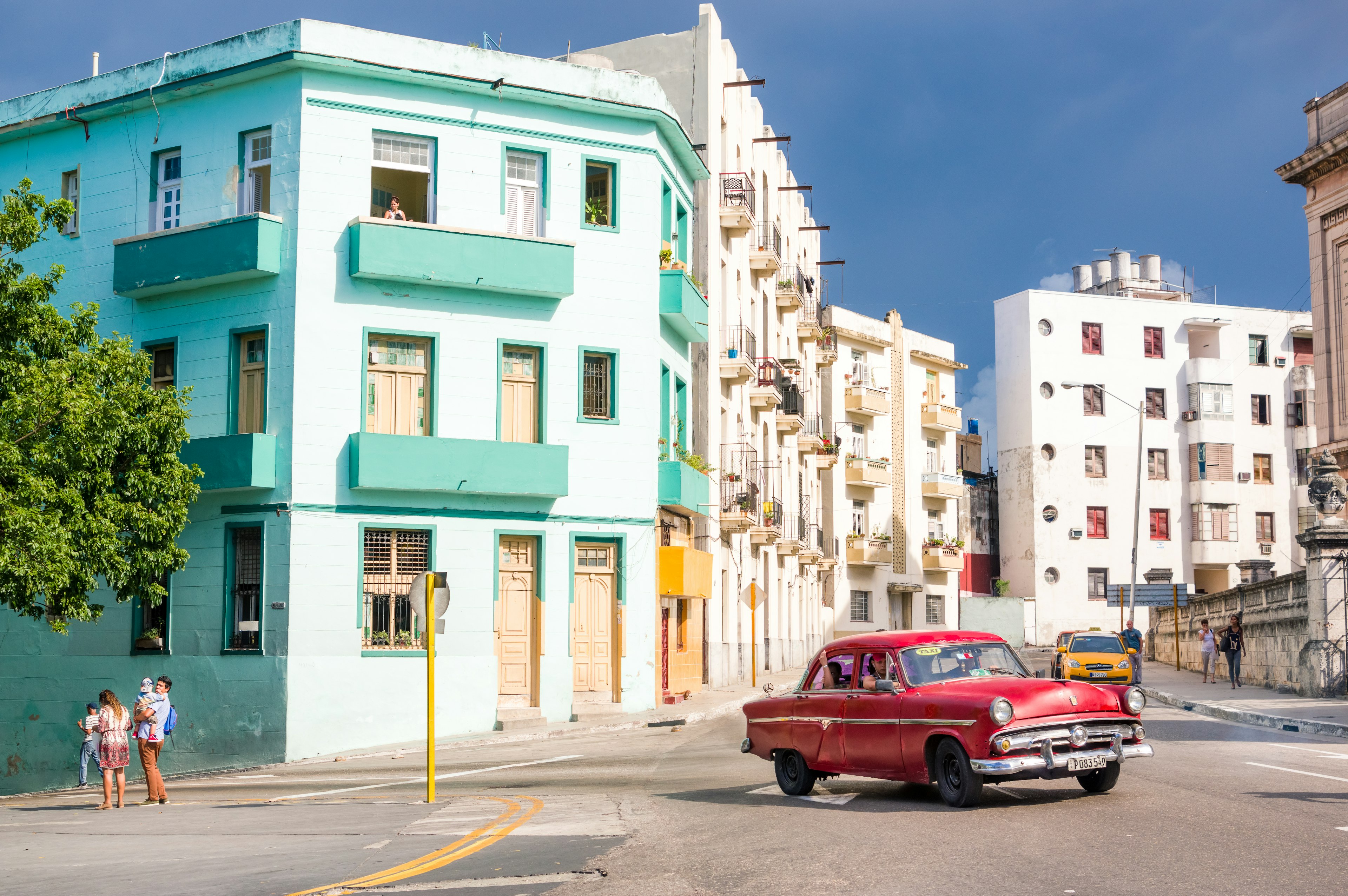 Colorful buildings and a classic car on a street in Havana