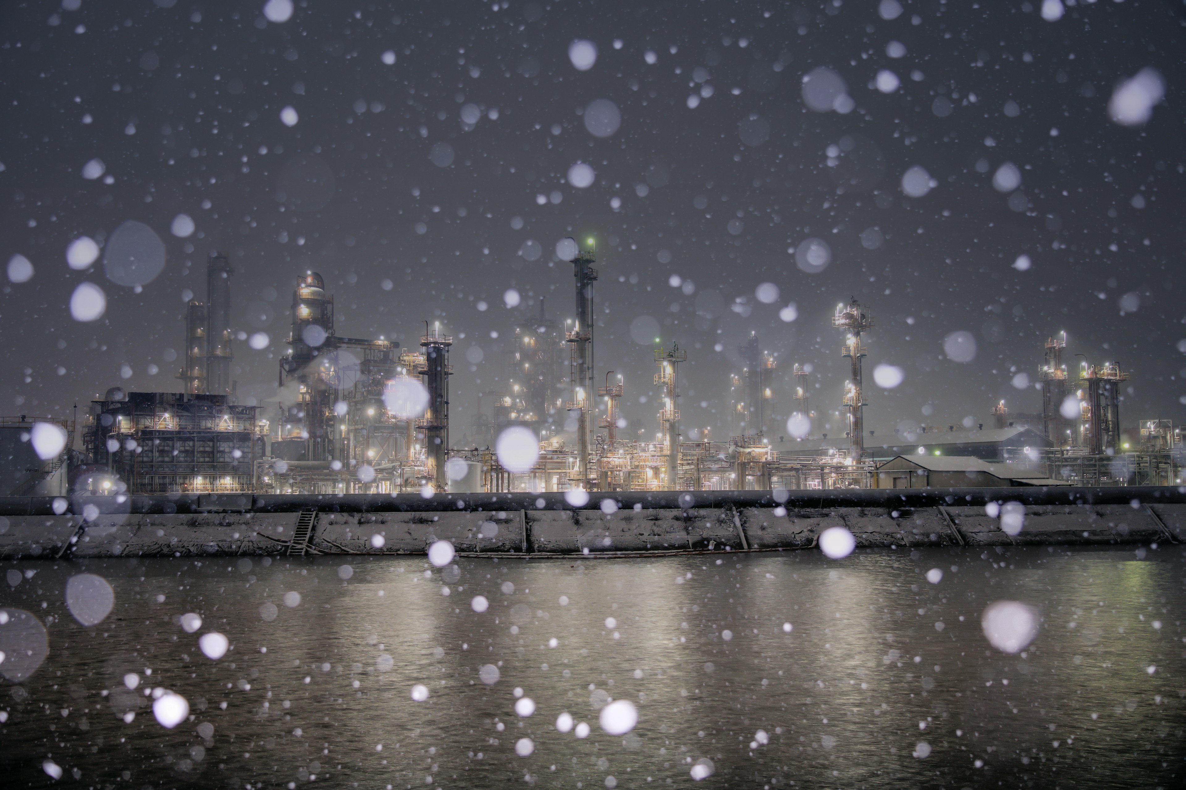 Night view of an industrial area with falling snow