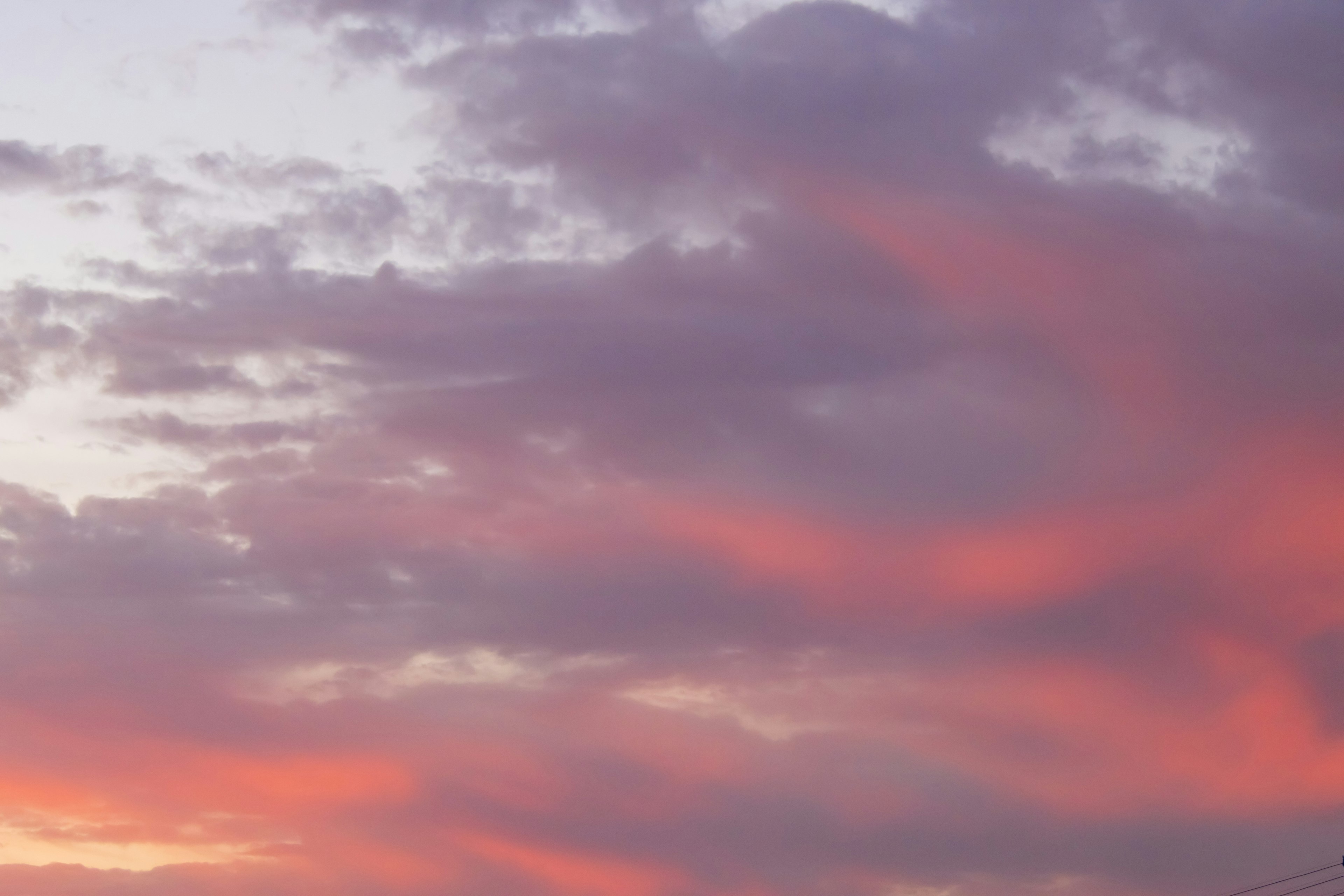 夕焼けの空に広がる淡い紫とオレンジの雲