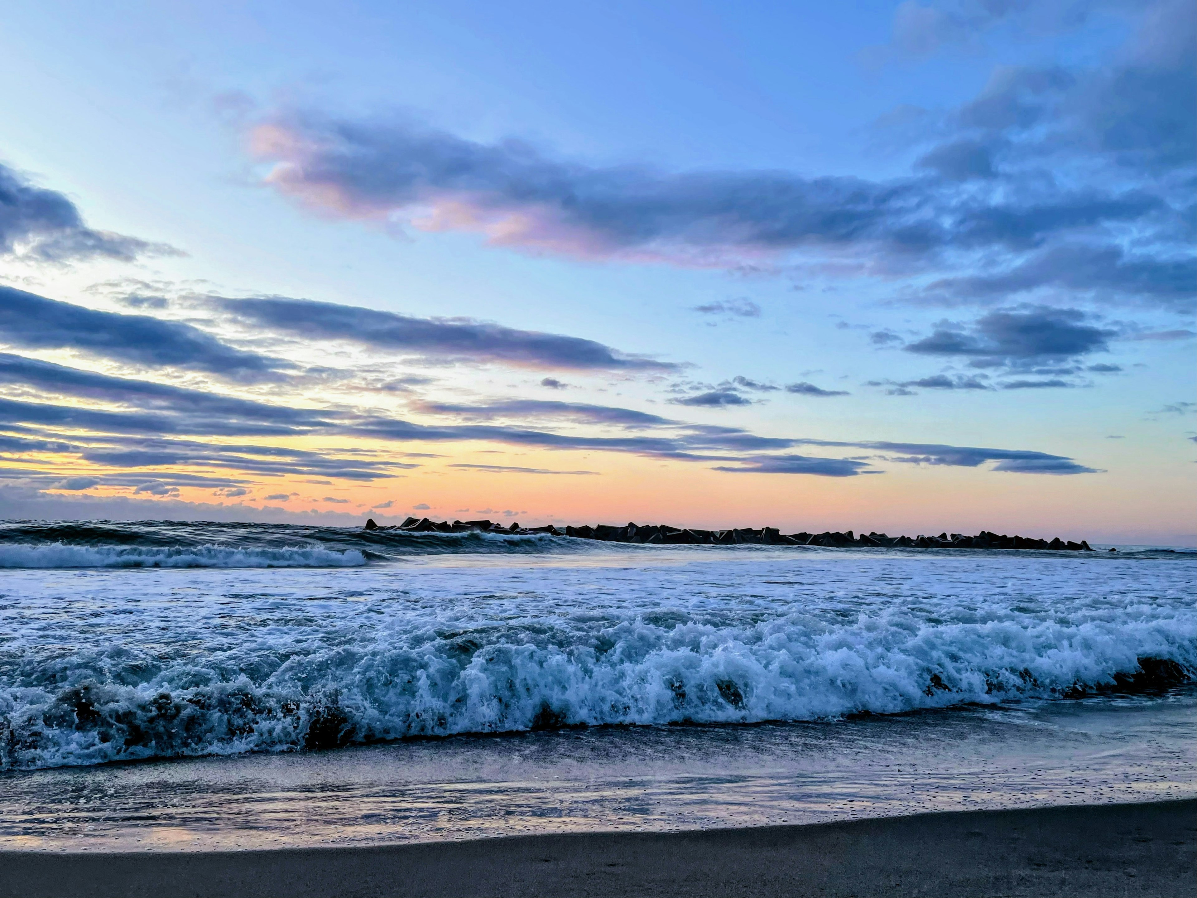 Pemandangan laut dengan ombak dan langit senja